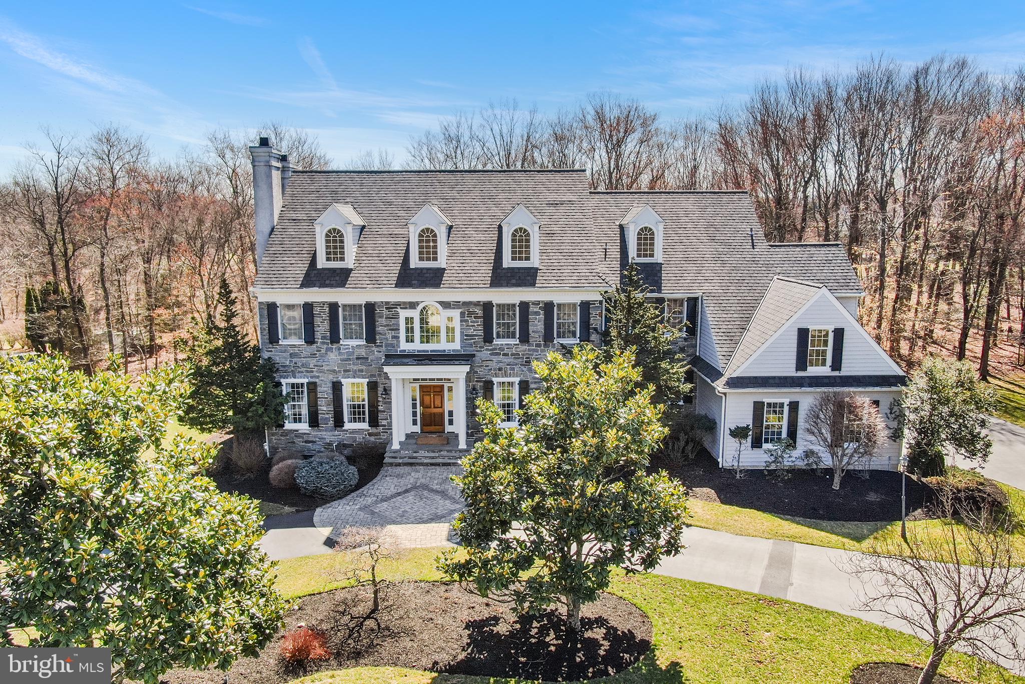 Nestled on 2.6 picturesque acres in the prestigious Dovecote Lane neighborhood, a private cul-de-sac of just 10 homes, this custom-built 2000 home blends timeless elegance with modern comfort. A grand circular driveway leads to a stunning entryway, where a front-to-back foyer with an elegant staircase sets the stage. The formal living room features a cozy gas fireplace, while the dining room showcases intricate woodwork. A well designed butler’s pantry provides seamless access to the kitchen and back staircase.

The kitchen offers abundant cabinetry, generous counter space, an island with seating for four, and a built-in desk area. The sunlit breakfast room overlooks the serene backyard and opens to a flagstone patio with a built-in gas grill—perfect for outdoor entertaining. The inviting family room boasts a coffered ceiling and a wood-burning fireplace, while the first-floor office with custom built-ins features a third gas fireplace. Additional conveniences include an oversized formal powder room, a mudroom with a secondary powder room, and a three-car garage.

Upstairs, the primary suite offers a sitting room, his-and-hers walk-in closets, and a spa-like bath with dual vanities, a walk-in shower, and a soaking tub. Two bedrooms have private en-suite baths, while the remaining two share a hall bath. A dedicated laundry room completes this level. The back staircase leads to a third-floor attic, offering potential for additional living space, while the over 2,500 sq ft unfinished basement provides room for ample storage and future expansion.

Meticulously maintained with an updated HVAC system, newer roof, and in-ground sprinkler system, this home is just minutes from the borough of Malvern, with boutique shops, restaurants, Amtrak and R-5 train service, and easy access to major highways and Philadelphia International Airport.