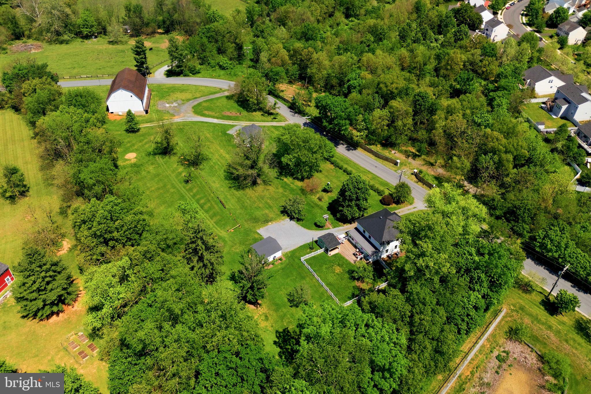 This property offers a rare opportunity to own one of Western Loudoun County's most distinctive historic properties—located just outside the charming town of Lovettsville and within walking distance of local restaurants, shops, the grocery store, and year-round community events. 

Built in 1923, the fully restored Four Square farmhouse seamlessly blends timeless character with modern convenience. Renovated and reconstructed by a well respected local builder, the home has undergone a comprehensive restoration includes updated and replacing all of the electrical, all of the plumbing, brand new HVAC system, water treatment system, and all new windows. The remodeled kitchen is designed for both everyday living and entertaining, complete with quartz countertops, custom cabinetry, a center island, and double ovens. Throughout the home, historic charm has been thoughtfully preserved while incorporating the comforts today's owners expect.

Adding even more value is the detached one-bedroom, one-bath guest cottage (ADU), completed in 2023 above the original spring house. Whether used for visiting family and friends, a private home office, multigenerational living, or a short-term rental, this versatile space offers excellent income-producing potential.

The property's historic bank barn is equally impressive and presents endless possibilities. The barn has recently been used to host family celebrations, including a wedding, the barn is well-suited for events, hobbies, storage, or equestrian pursuits. Horse enthusiasts will appreciate the fenced paddock, seven stalls, tack room, frost-free well hydrant, and electricity throughout. With its flexibility and unique character, the barn offers another opportunity for future income generation.

Properties like this rarely come to market. Combining historic significance, extensive modern updates, income-producing opportunities, and a walkable small-town location, this exceptional estate offers a lifestyle that is increasingly difficult to find—and impossible to replicate.