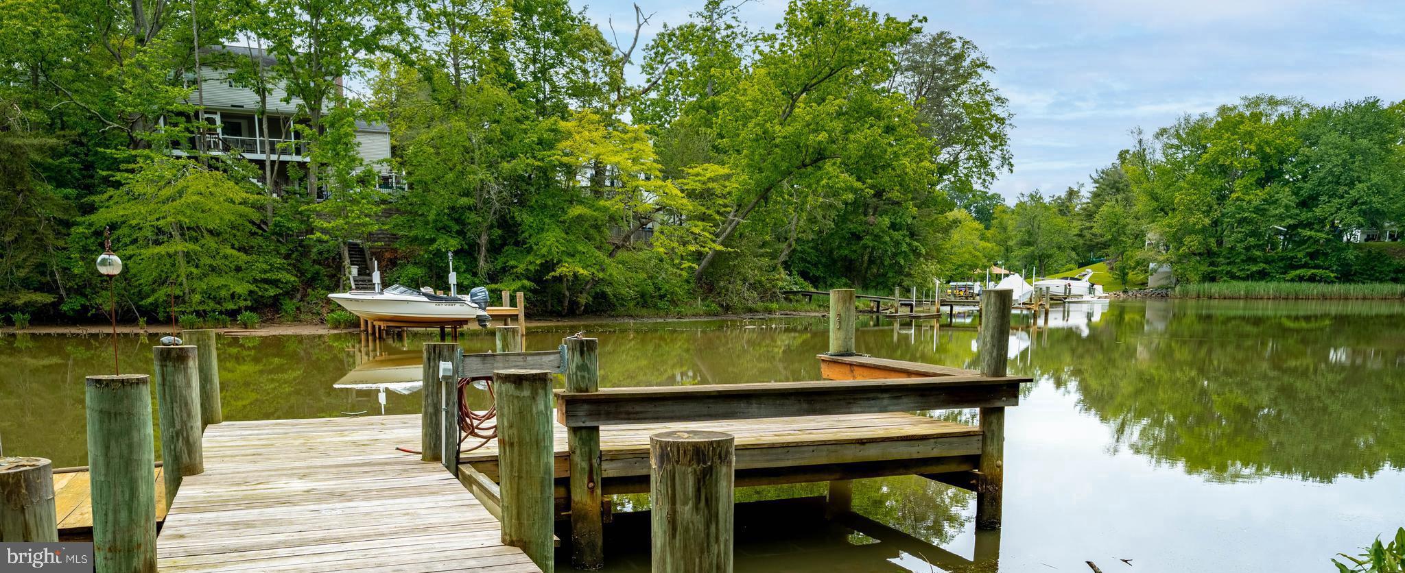 A private waterfront retreat designed for entertaining, multigenerational living, and the classic Chesapeake Bay lifestyle. With 4 bedrooms, 3.5 baths, and panoramic water and woodland views, 771 Macsherry Drive offers a lifestyle that feels both private and inspiring.

Inside, classic hardwood floors and  modern elegant windows create a light-filled atmosphere designed to bring the outdoors in. The thoughtfully designed floorplan showcases sweeping water views while offering comfortable spaces for entertaining flow and relaxing alike.  A flowing floorplan includes a spacious family room, morning room, living room, and dining room all centralized around a modern kitchen. Upstairs, you'll find three bedrooms overlooking the water. The stunning primary suite is a true sanctuary, featuring oversized closets, private balcony access, and a renovated spa-inspired luxury bath with an expansive walk-in shower (2025).

Outdoor living takes center stage with expansive decks, two private balconies, and a beautifully updated dock ready for boating, kayaking, or simply enjoying peaceful waterfront sunsets. These spaces are designed to delight you and your guests in every way. From an afternoon nap in the hammock, to a waterfront BBQ for your whole crew, this home has spaces to accommodate every activity. And when you're ready to relax, a separate cottage with a brand-new hot tub (2023) creates the perfect getaway space.

Ideal for separate living or long-term guests, the home also features a true in-law suite fully renovated in 2021, with its own private entrance, full kitchen, and separate laundry. Additional highlights include durable HardiPlank siding (2024), a spacious two-car garage with EV chargers (2023), and the peace of mind of a 17kW Generac whole-house backup generator.

This is a rare opportunity to own a waterfront home that seamlessly combines architectural style, flexible living spaces, and coastal-style amenities in one of the region’s most tranquil settings.