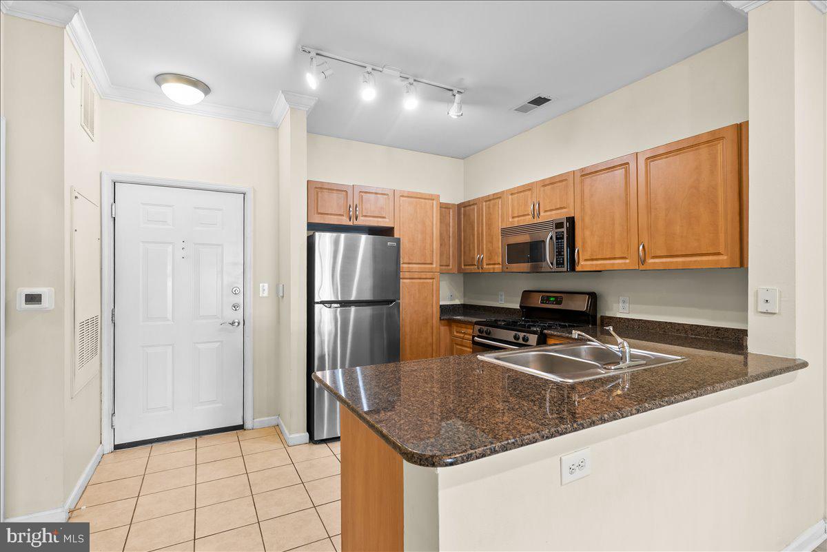 Convenience and comfort come together in this  ground floor condo, perfectly located just minutes from the Silver Line Metro, Dulles Airport, and major commuter routes including Route 28, I-66, and Fairfax County Parkway. Even better, grocery stores, restaurants, and everyday essentials are right across the street, making errands and dining out a breeze.

Inside, you'll find an open and welcoming layout featuring 9-foot ceilings, a spacious bedroom with an en-suite bath, and a well appointed kitchen with granite countertops, stainless steel appliances, and maple cabinetry. Step outside to your private patio, the perfect spot to enjoy your morning coffee or unwind after a long day.

Located in a gated community packed with amenities, residents enjoy access to a swimming pool, fitness center, clubhouse, picnic areas, and BBQ grills. Whether you're looking for a low-maintenance home or a convenient commuter-friendly location, this condo offers the best of both worlds.