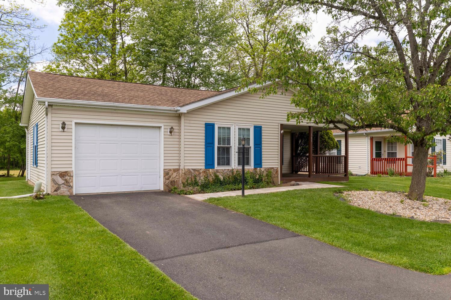 Privacy in Buckingham Springs! This inviting Gwynedd Model features a cozy front-to-back layout with 2 bedrooms and 2 bathrooms, as well as an attached Garage. Enjoy the warmth of a fireplace during colder months, but right now the beauty of this place is the sunroom looking out on the trees with no neighbors behind you and a wide open space next door. Updated windows and HW Heater. The community offers fantastic amenities, including a clubhouse and pool, fostering a vibrant social atmosphere managed by a professional team. Easy access to Doylestown, New Hope, and Newtown, as well as I-95. This is a great opportunity to get into a Gwynedd model and share in a low-maintenance, high-fun lifestyle!