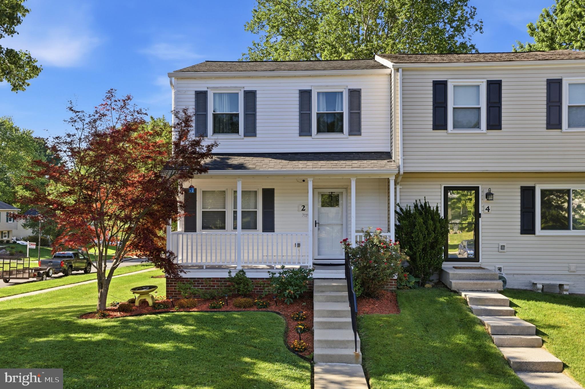 Welcome to 2 Bush Hill Court — a beautifully updated, move-in-ready end-unit townhome that lives larger than its footprint, with extra side-yard green space, professionally landscaped grounds, and natural light on three sides. A covered front porch sets the tone before you step inside.
The main level showcases warm hardwood floors, crown molding, and a bright, open living and dining area anchored by a custom reclaimed-wood accent wall. Sliding glass doors lead to a private deck overlooking the trees. At the heart of the home, the fully renovated galley kitchen features white shaker cabinets, quartz countertops, stainless steel appliances, and a classic subway-tile backsplash.
Upstairs, the primary bedroom offers a private bath and a generous closet, with additional bedrooms featuring custom closet built-ins and durable wide-plank flooring. The renovated full bath continues the home's elevated finishes with marble-look tile and a modern floating vanity.
The walk-out lower level adds valuable living space — a finished recreation room with built-in shelving, opening directly to a covered patio and backyard. A separate utility area houses the laundry and ample storage.
Move-in ready, with stylish, modern updates throughout.