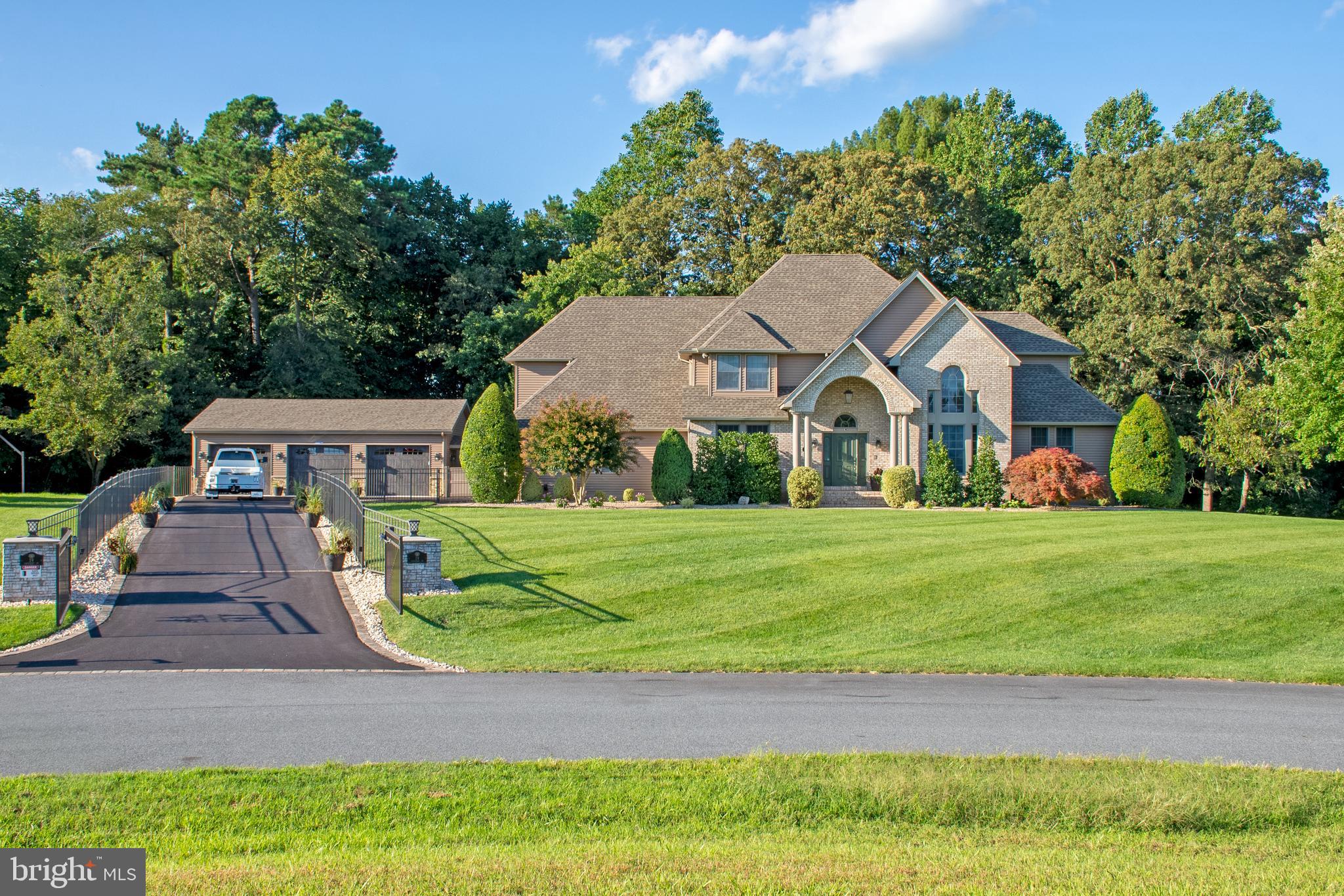 "The Dream Home" – A spectacular contemporary custom-built estate where luxury, craftsmanship, and resort-style living come together in the prestigious Haven Lake Estates.

From the moment you arrive, this extraordinary residence makes a lasting impression. A gated entrance with elegant wrought-iron fencing opens to a lighted asphalt driveway accented with pavers, leading to the recently constructed, climate-controlled three-car detached garage. Every detail has been thoughtfully designed to create a truly one-of-a-kind property.

Step inside the grand two-story foyer featuring soaring ceilings, a sparkling chandelier, and a dramatic curved staircase leading to the second-floor catwalk overlooking the main living area. Just beyond, a sun-filled sitting room provides the perfect retreat to enjoy a quiet morning with coffee and the day's news, while the formal dining room is ideal for hosting memorable holiday gatherings and elegant dinner parties.

The gourmet kitchen is a chef's dream, showcasing a newly expanded center island with abundant storage, custom cabinetry with accent lighting, hard-surface countertops, a farmhouse sink, and brand-new stainless steel appliances, including a gas range with a drop-down exhaust. The adjoining breakfast area overlooks the beautifully landscaped backyard, creating the perfect setting for casual dining.

The breathtaking great room serves as the heart of the home, highlighted by a stunning floor-to-ceiling custom built-in entertainment wall and an impressive wall of windows that frame picturesque views of the outdoor living space, heated in-ground pool, wooded backdrop, and gently winding brook.

The privately situated first-floor primary suite is a luxurious retreat featuring separate walk-in closets and a spa-inspired bath complete with a walk-in shower, porcelain soaking tub, double vanity, and a modern digital mirror.

The second level offers a private guest suite with its own full bath and walk-in closet, two additional generously sized bedrooms, and another full bathroom. A spacious bonus room with its own private bath, built-in entertainment center, and adjoining office with custom workspace provides endless possibilities as a home office, media room, guest quarters, or recreation space.

The finished lower level is equally impressive, featuring a dedicated theater room with surround sound and recessed lighting, along with additional flexible space perfect for a home gym, yoga studio, craft room, or game room. Ample storage with built-in shelving completes the basement.

Designed for both entertaining and everyday enjoyment, the outdoor living spaces rival a private resort. The fenced backyard features a recently installed heated in-ground pool, expansive paver patio, newer deck, fully equipped outdoor kitchen with plumbing, pergola, relaxing hot tub, fire pit, gazebo, playground area, and generous green space for gardening or recreation. Recently installed sod and professional landscaping further enhance the beauty of this remarkable property.

Additional highlights include a main-level laundry room with overhead cabinetry, an attached three-car garage, a recently replaced roof and siding, a tankless water heater, and meticulous maintenance throughout.

Conveniently located within easy driving distance of major metropolitan areas, Delaware's award-winning beaches, and popular coastal destinations, this exceptional estate offers the perfect blend of luxury, privacy, and convenience. More than just a home, it is a lifestyle—a private oasis you'll never want to leave.