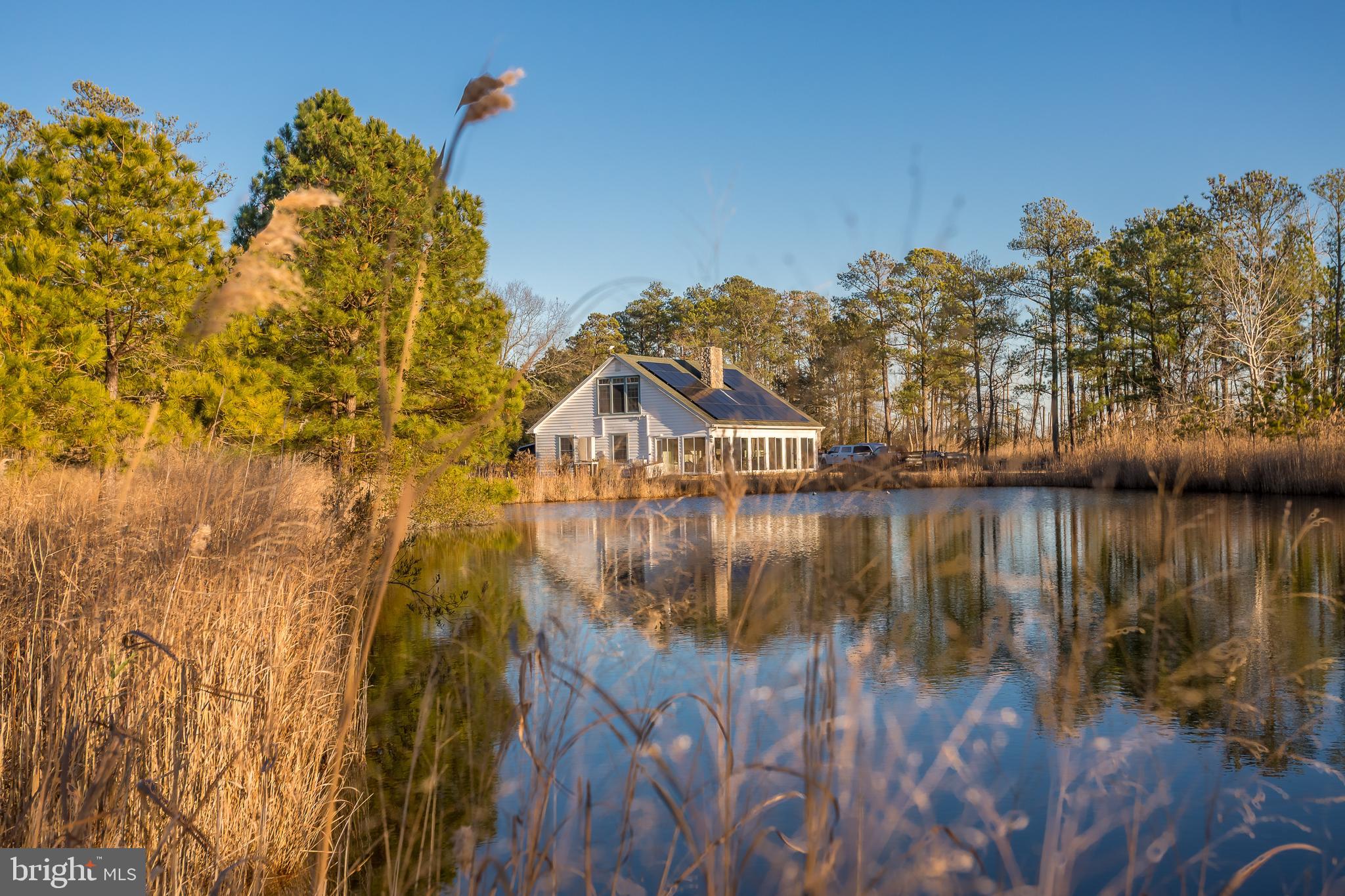 Situated as the last privately owned property on Maple Dam Road before entering Blackwater National Wildlife Refuge, this 10.54± acre offering occupies an exceptional setting surrounded by refuge lands on all sides. The property lies within thousands of acres of permanently protected public ground, providing unmatched privacy, wildlife presence, and long-term landscape preservation in the heart of Dorchester County.

Improvements include a 1,718± square-foot residence powered by a PV solar array, backed by an on-demand 22kw generator delivering efficient and sustainable energy. Climate control is handled by six mini-split systems, with an additional in-box unit conveying with the sale, offering flexibility for future expansion or replacement. The home features two gas fireplaces, with one having an option to burn wood, adding both comfort and versatility. A four-person hot tub is included, creating an ideal space to unwind and watch the sunset.

A 30’ x 30’ garage with 14-foot ceilings provides ample room for boats, equipment, and sporting gear. in addition to the large garage, a climate-controlled office/workshop is just steps away from the main house. The land itself is highlighted by natural marsh ponds and wetlands, enhancing habitat and contributing to the area’s outstanding waterfowl hunting and well-established Sika deer population.

This property offers a unique opportunity to enjoy legitimate hunting and outdoor recreation from a private home site while being fully immersed within one of Maryland’s most iconic conservation landscapes. Whether used as a full-time residence, weekend retreat, or generational sporting property, Maple Dam Road delivers an exceptional blend of access, privacy, and outdoor heritage that is increasingly difficult to find on the Eastern Shore.

A BAT System upgrade plan has been developed to bring BAT/BIP System up to standards. Contact for additional information.