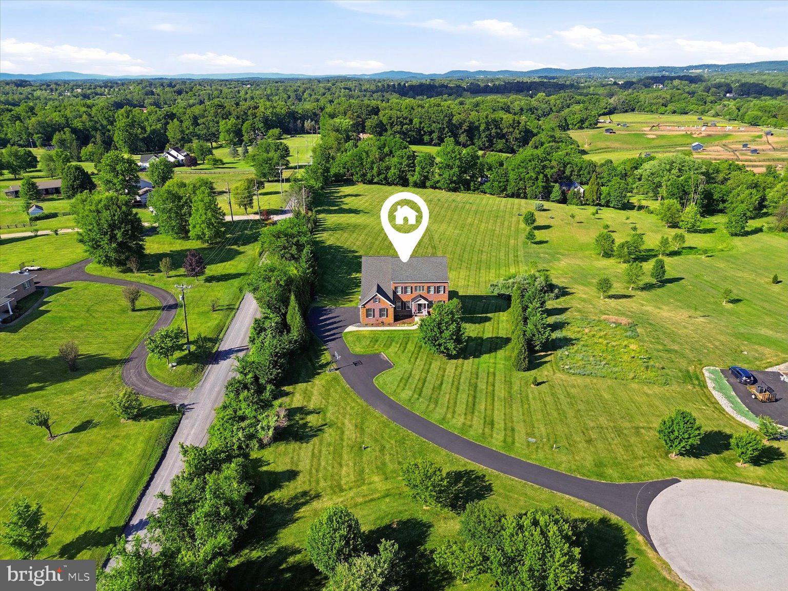 Welcome to this meticulously maintained single-family home nestled on 3 beautiful acres in the heart of Hamilton, where privacy, elegance, and convenience come together to create the perfect place to call home. From the moment you step into the impressive two-story foyer, you'll appreciate the thoughtful design and timeless appeal of this exceptional property. The formal living room sits to the right of the entry, while the formal dining room to the left provides the perfect setting for holiday gatherings and special occasions. A spacious main-level office with a charming bay window offers an ideal work-from-home space, while a convenient powder room completes the main level. At the heart of the home is the beautifully appointed kitchen featuring a large center island, granite countertops, cooktop, wall oven, stainless steel appliances, and a casual dining area perfect for everyday meals. Plantation shutters, added in 2018, enhance the home's warmth and character. Just beyond the kitchen, step out to the expansive Trex deck and screened porch, where you can enjoy peaceful mornings, outdoor dining, and breathtaking views of your private surroundings. The adjoining family room is truly spectacular, showcasing a floor-to-ceiling stone gas fireplace, coffered ceilings, and an abundance of windows that fill the space with natural light. A practical mudroom adds everyday convenience. Upstairs, the luxurious owner's suite serves as a private retreat with a spacious sitting area, large walk-in closet, and a beautifully updated owner's bath. Two secondary bedrooms share a Jack-and-Jill bath, while an additional bedroom enjoys its own private full bath, providing comfort and privacy. The home features 9-foot ceilings on both the upper and lower levels, enhancing the sense of openness throughout. The walkout lower level offers exceptional flexibility with a large recreation room, a spacious bedroom with a generous closet, a full bath, and an additional room that can easily serve as a second home office, fitness room, hobby space, or guest room. Two large unfinished storage areas provide ample room for seasonal items, tools, and future possibilities. Adding even more value, the home is equipped with a water filtration system for enhanced comfort and peace of mind. Surrounded by mature landscaping and open space, this property offers peace and  tranquility while remaining just minutes from shopping, dining, schools, and everyday conveniences. Opportunities like this are rare—an impeccably maintained home on 3 acres in one of Hamilton's most desirable locations. Come fall in love, imagine the memories waiting to be made, and make this exceptional property your forever home. Photos may be virtually staged