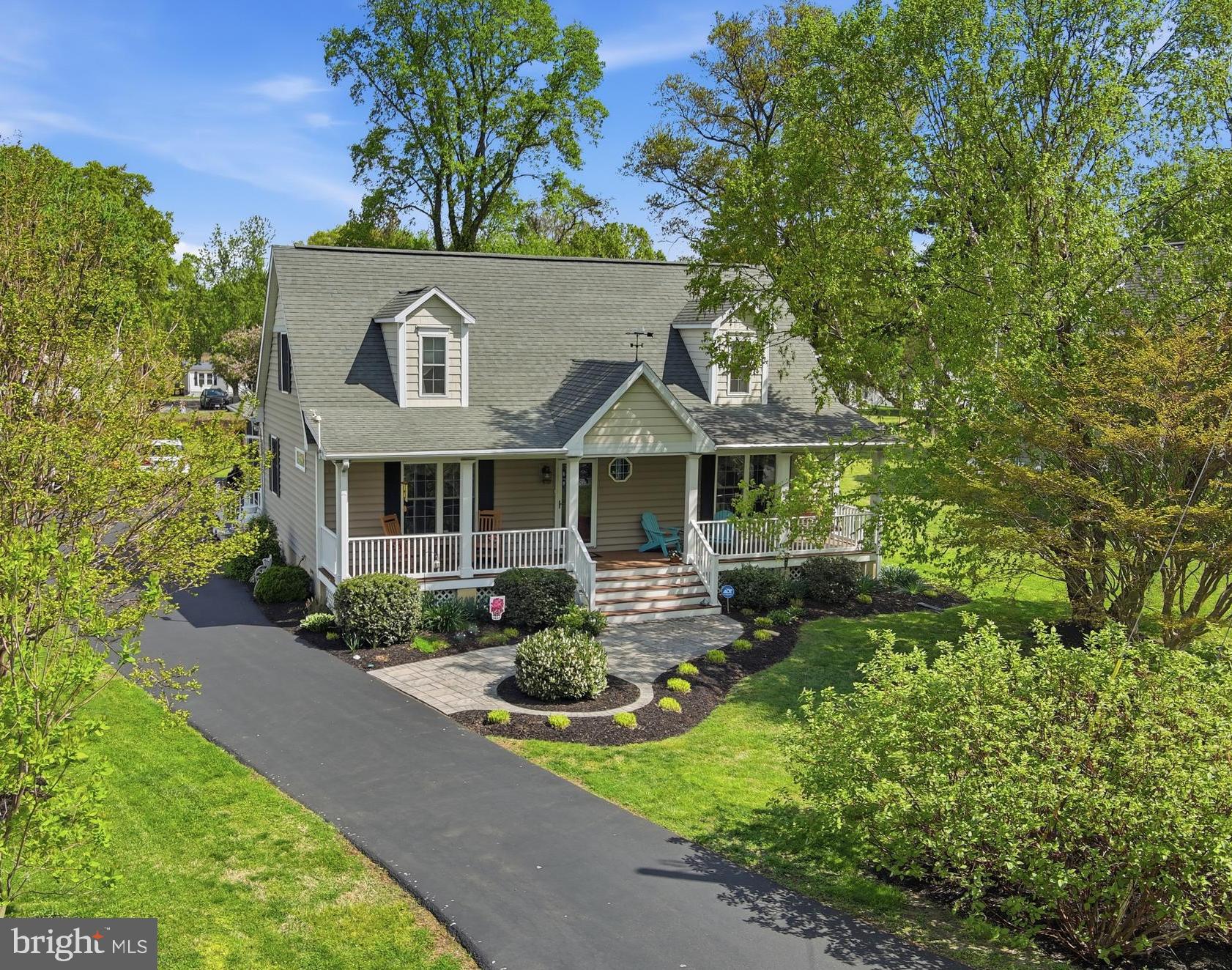 Spacious in-town home with coastal charm, just 1 block from the Rock Hall beach on the Chesapeake Bay! 
This home offers a luxe front porch, as well as a screened-in porch, perfect for meals and entertaining. The large family room boasts a gas fireplace, built-in shelving, wood ceilings, and a sunny balcony featuring a striped awning. 
The eat-in kitchen has updated appliances and ample room; it opens up to the front sitting room. Just around the corner is the light-filled formal dining room.
Two first-floor bedrooms share a full bathroom. Two additional bedrooms upstairs share a full bathroom. This home offers the sought after first floor living option, with ample room for guests. 
There is a two-car garage with interior access and plenty of room for storage, hard to find in Rock Hall. 
The outside has been lovingly landscaped. 
This property is move-in ready for the summer! A short distance to the Rock Hall beach, many dining options, ample marinas, and shops. Don’t miss this in-town gem!