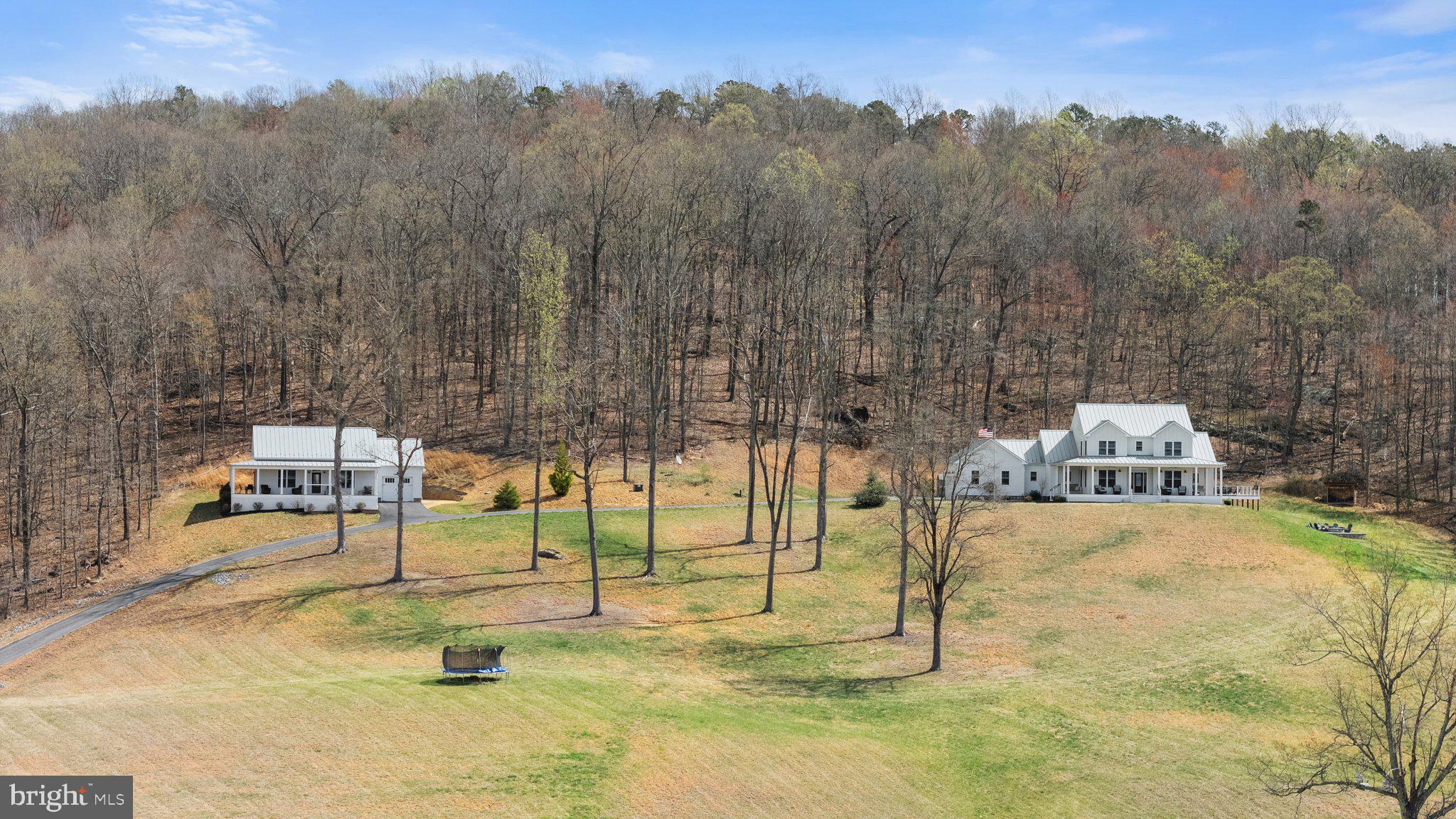 Welcome to 9550 Poorhouse Road in Marshall, Virginia—an extraordinary property offering two beautifully designed modern farmhouse-style homes on over 14 peaceful acres with rolling hills, stunning mountain and water views, and unforgettable sunsets. Enjoy the feeling of seclusion while benefiting from remarkably quick access to the charming towns of Marshall and Warrenton, as well as convenient entry to I-66, connecting you effortlessly to broader destinations.

The main home is a true showstopper, featuring four spacious bedrooms, four full bathrooms, and a half bath. The main-level primary suite offers comfort and convenience, while the expansive layout includes a finished basement, designed for the ultimate entertainment experience! Here you'll find a dedicated movie theater complete with a star-covered ceiling for cinematic adventures and a convenient concessions area, as well as a wet bar, perfect for hosting unforgettable gatherings. The home also boasts an in-ground saltwater pool and fire pit, blending luxury with laid-back country living.

The second home is a charming 990 square-foot dwelling with two bedrooms and one bathroom. This residence includes a stunning kitchen with vaulted ceilings, a wrap-around porch for enjoying the views, and an oversized one-car garage.

Both homes feature tasteful modern farmhouse finishes throughout. Inside, comfort and efficiency are paramount. The homes feature dual-fuel HVAC systems for optimal climate control throughout the seasons. The exteriors boast durable and low-maintenance Hardi Board siding, robust metal roofs, and composite decking, ensuring lasting quality and minimal upkeep. Step out onto the expansive covered porches and decks, providing ideal vantage points for enjoying the stunning mountain views and perfect for entertaining guests or simply unwinding in nature.

This rare property combines luxury updates, expansive land, and unparalleled entertainment spaces — all just minutes from the town of Marshall. Don't miss the chance to own this extraordinary mountain retreat at 9550 Poorhouse Rd. Schedule your private showing today!