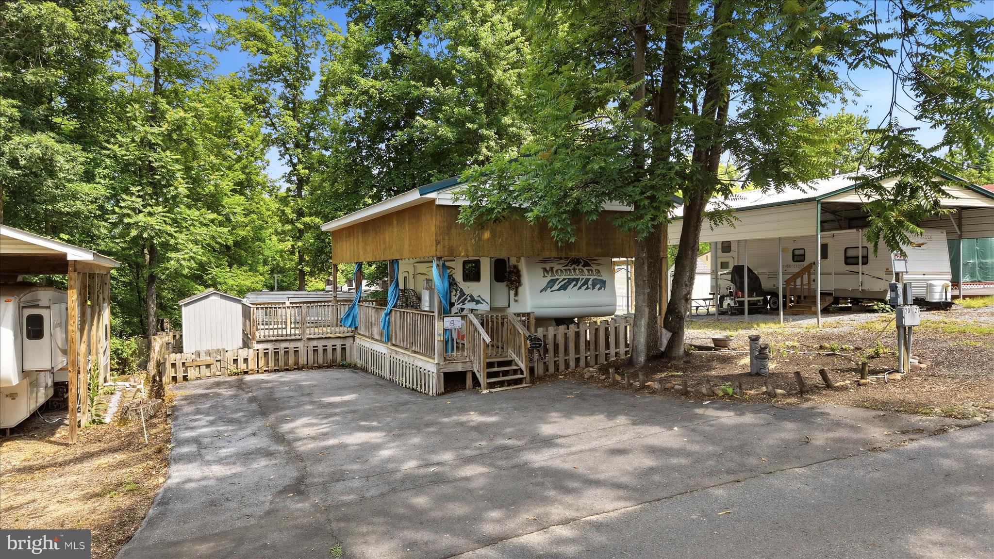 Looking for a lot and an RV near the beautiful Potomac River?  This level lot with nice shade trees has a 2005  39’ Montana 5th wheel covered by a permanent pavilion that extends for extra covered deck space to grill, sit, or play—full hook-ups—including water, sewer, a 50-amp receptacle—and a convenient storage shed. There’s ample room for guests, vehicles, or all your favorite water toys in the paved driveway. The fenced-in backyard offers additional entertainment space and a fire pit. As part of the seasonal community, you’ll enjoy an array of amenities such as swimming pools, tennis courts, playgrounds, miniature golf, and a welcoming clubhouse—all covered by the HOA fee. The community’s spectacular Fourth of July fireworks show is a local highlight you won’t want to miss. Just steps from the river, you can spend your days swimming, boating, or fishing. Members also benefit from discounted guest passes and have the option to join the boat club for easy boating access. Whether you're seeking a peaceful weekend getaway or a seasonal home base, this lot offers freedom, recreation, and an unbeatable location. Seller has paid 2026 Membership dues.