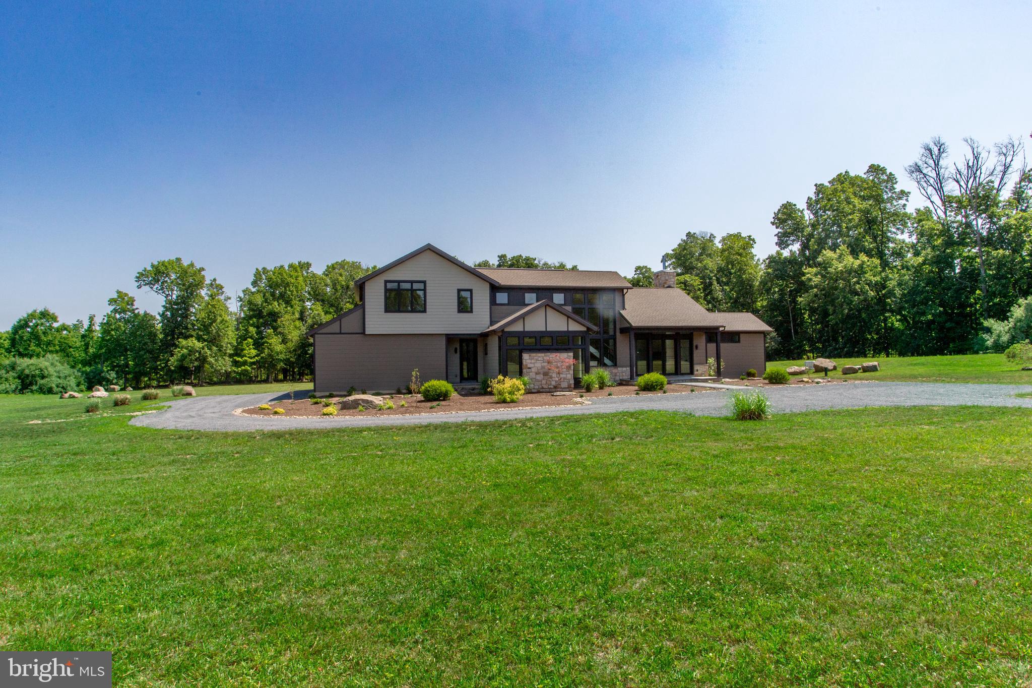Treasure nature, privacy, a unique floor plan, elegance, comfort, and land? An exciting
opportunity awaits to own a luxury contemporary house ,quality
built with superb craftsmanship, sophisticated taste, style, and beautiful architectural
features and details. On a  scenic country road , the house is surrounded by 5.39 acres of flat land with woods along the perimeter. Windows and doors with unobstructed glass are the main design element so nature is part of your décor and natural light rules. The covered bluestone front entry and sitting area has a wall of glass panels that include a double door. Step inside and you will see the spectacular great
room and showstopper kitchen.  Imagine the decorating opportunities. The
central area of this home has an 18’ vaulted ceiling, chandelier, propane fireplace with
raised hearth, and a dramatic 2-story wall of windows that is the backdrop for the wide
staircase to the second level. The chef’s dream kitchen leaves nothing wanting.
Perimeter cabinetry is solid maple painted a soft beige color and the 10’ island is white
oak  has a farmhouse Fireclay  sink, dishwasher and microwave
shelf. GE Monogram stainless steel appliances, Quartz countertops, propane 6-burner
range, champagne bronze knobs, hardware, faucet and pendants, built-in wine
refrigerator, bar sink, undercounter lighting and a popup electrical outlet in the
countertop. Beauty, efficiency, function and lots of space. On one side of the great room
is a large open den/dining room and near the kitchen is a den/office .
Behind the kitchen is a hall with porcelain floor with door into the oversized 3-car
garage, two closets, laundry room with copper farmhouse sink and full bath .  An exterior door to the
rear patio also accessed from the kitchen and dining room. A convenient exterior front
entrance door opens into this mudroom  area and is close to the kitchen. The primary
bedroom/bathroom suite is on the main level! Bedroom features a propane fireplace and
a separate closet/dressing room with custom full height built-in cabinetry. Primary
bathroom has custom vanity with two sinks, separate glass front shower, and large
soaking tub. The second floor has a laundry area in the hall, bathroom for two
bedrooms, and a third bedroom with ensuite bathroom. Plenty of closet space.
The  basement is 1,477 sf , a 9'  high ceiling, and Bilko
door. For relaxing and entertaining outside, you will love the covered 38’x15’ bluestone
patio with a propane line installed for future use.  Access is from kitchen, dining
room or laundry room. The storm management for this property allows an additional 1,000
sf to be built in the rear, i.e., pool, hardscaping, shed, tennis court, etc. If you love
nature, birds, animals, peace and tranquility, beauty and privacy you will appreciate the
character and ambiance of this spectacular home where the living surely will be easy,
Central Bucks Schools. Tax  improvement assessment is not available yet.
