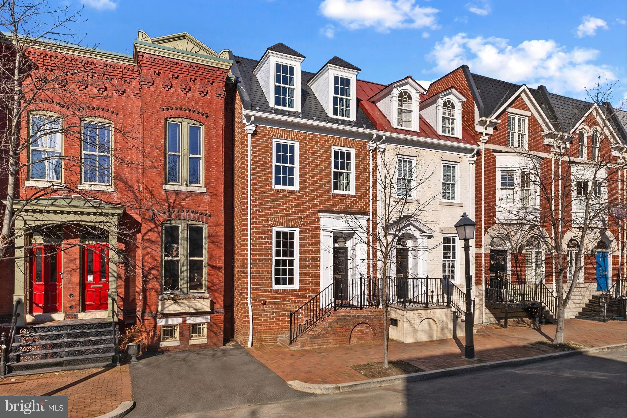 An extraordinary renovated home just steps from King Street, Metro, VRE and Old Town’s most iconic landmarks. Perfectly situated moments from acclaimed restaurants, boutique shopping, and the vibrant Old Town life. This residence offers the rare combination of walkable city living with the privacy and ease of refined, low‑maintenance ownership.

This exquisitely maintained home showcases extensive millwork, soaring ceilings, and timeless architectural details throughout. The inviting main level features 10-foot ceilings with custom crown molding, gleaming hardwood floors, and oversized new Marvin double hung windows that fill the home with natural light. The expansive living room is anchored by a wood-burning fireplace surrounded by custom built‑ins and opens to a spacious dining room—ideal for entertaining. The renovated eat‑in kitchen includes premium cabinetry, a pantry, and a built-in wine rack, providing both elegance and functionality.

Upstairs, the primary suite is a true sanctuary with vaulted ceilings, custom bookcases, and a second wood-burning fireplace overlooking the private back brick patio. The suite offers two large walk-in closets and a luxurious, spa‑inspired bath complete with a double vanity, an oversized two‑headed walk‑in shower, and abundant built‑in storage. Each of the home’s three generously sized bedrooms includes its own newly renovated bathroom with timeless finishes and high-end Kohler fixtures. A conveniently located upper-level laundry room adds everyday practicality.  The large walk in storage room is a rare find in Old Town.

Outdoors, a fenced private patio provides the perfect retreat for outdoor entertaining. A dedicated garden shed offers additional storage. The property also includes two deeded off‑street parking spaces located directly behind this home. Parking spaces #1

Impeccably maintained and thoughtfully updated, this residence is defined by its craftsmanship, comfort, and character. From its new slate roof and gutters to its sophisticated interior finishes, every detail reflects luxury living in historic Old Town Alexandria. Its in turn key condition.