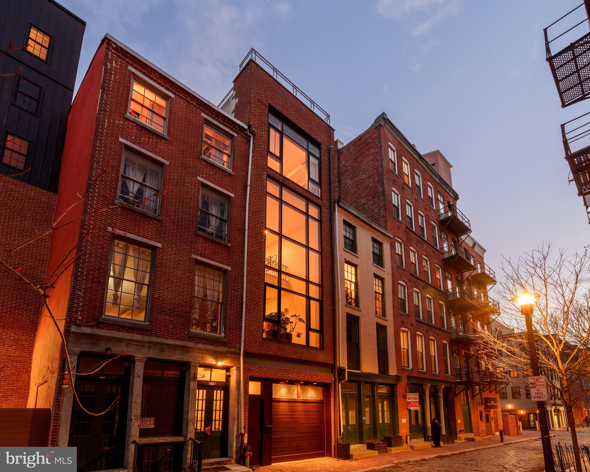 Architecturally unique Minimalist townhouse built 2005. Designed by Janice Woodcock & Associates of Old City, Philadelphia.

This Glass Curtain Wall Facade, 4 story home, is located on the cobblestone alley behind historic Christ Church and the Arden Theater, both are pillars of the Old City community.

1st Floor:

Mixed use space. Entrance to house and 2 car temperature controlled tandem garage. Mirrored Gym/Yoga studio. Big Ass Haiku Fan. Full Bath. Lots of storage space, generous (1,000+ bottles) Wine Cellar with N’finity SC3000 Whisperkool climate control system. Murphy bed for overnight guests.

2nd Floor:

Main living space consists of central atrium soaring 40’ to top of 12’ skylight. The translucent stairs wrapping around this space lead all the way to the 3rd Floor. Living room on this floor has 22’ H window facing the street below. The floors are 3/4" solid wood “Character Hickory”. Kitchen/Dining areas are on alternate side of central atrium. Lacquered Cherry cabinetry and Viking appliances throughout. Counter tops and Island are black granite. There is a powder room off of the atrium, and sliding glass doors lead to a small deck off of the dining area where you can grow herbs, cook your dinner on a real charcoal grill, or simply enjoy a glass of wine.

3rd Floor:

Cosy loft seating area with gas fireplace looks down into the 2nd floor living room, and directly out to the same 22’ glass curtain wall. On the alternate side of the open central atrium are two bedrooms and a full bath in between. These rooms could also be used as offices, or dens.

4th Floor:

Primary Bedroom Suite constitutes the entire 4th floor. The bed chamber has a floor to ceiling window (which completes the “curtain wall effect from the exterior) with a vivid view of the Christ Church steeple. The hallway leading to the walk in closets, laundry room and full bath with oversized shower, passes along the open central atrium just beneath the large skylight. The natural light in this space is wonderful. The bath chamber also boasts a free standing soaking bathtub and acres of Calacata Borghini Carrara marble tile.

Rooftop Deck:
Reached by hardwood stairs from 4th floor. Great views of the Christ Church Steeple, Ben Franklin Bridge, and the U.S. Customs House

*Some photos are virtually staged