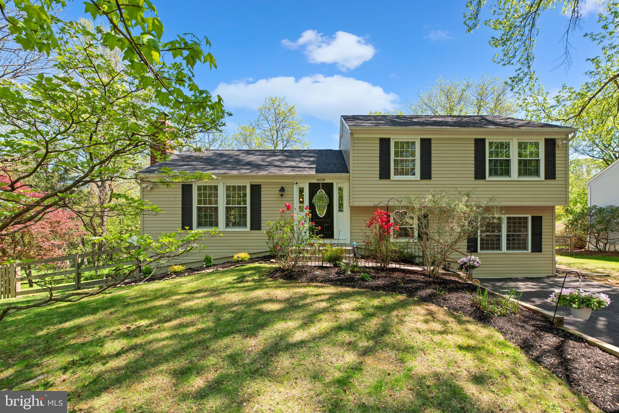 Beautifully updated split-level home offering 2,472 square feet, 4 bedrooms, and 3 full bathrooms nestled on a peaceful cul-de-sac in desirable Stevens Forest. A spacious, landscaped front yard sets a welcoming tone, leading into the open-concept main level where vaulted ceilings with exposed beams add character. Hardwood floors extend through the bright living room, highlighted by a striking floor-to-ceiling stone wood-burning fireplace flanked by built-in bookshelves. The adjoining dining area features a timeless chandelier and opens to a stunning three-season sunroom with panoramic windows and skylights—perfect for relaxing. The stylish eat-in kitchen boasts a large L-shaped island with breakfast bar seating, stainless steel appliances, granite countertops, chic pendant lighting, a decorative backsplash, and an abundance of cabinetry, including elegant glass-front cabinets for display. Upstairs, hardwood flooring continues into three generously sized bedrooms, including the serene primary suite. The primary bedroom offers double closets, a bold accent wall with coffered detailing, and a beautifully tiled en suite bathroom with a rainfall showerhead. A second full bathroom in the hallway serves the remaining two bedrooms. The bright lower level provides a spacious recreation room, a fourth bedroom, a full bathroom, and a laundry/storage area with a convenient exterior exit. Step outside to enjoy the rear deck, stepping down to a fully fenced yard with thoughtful landscaping and a charming stepping stone pathway. The yard backs to a tranquil pond, mature trees, and a scenic path, creating a peaceful natural backdrop for everyday living.