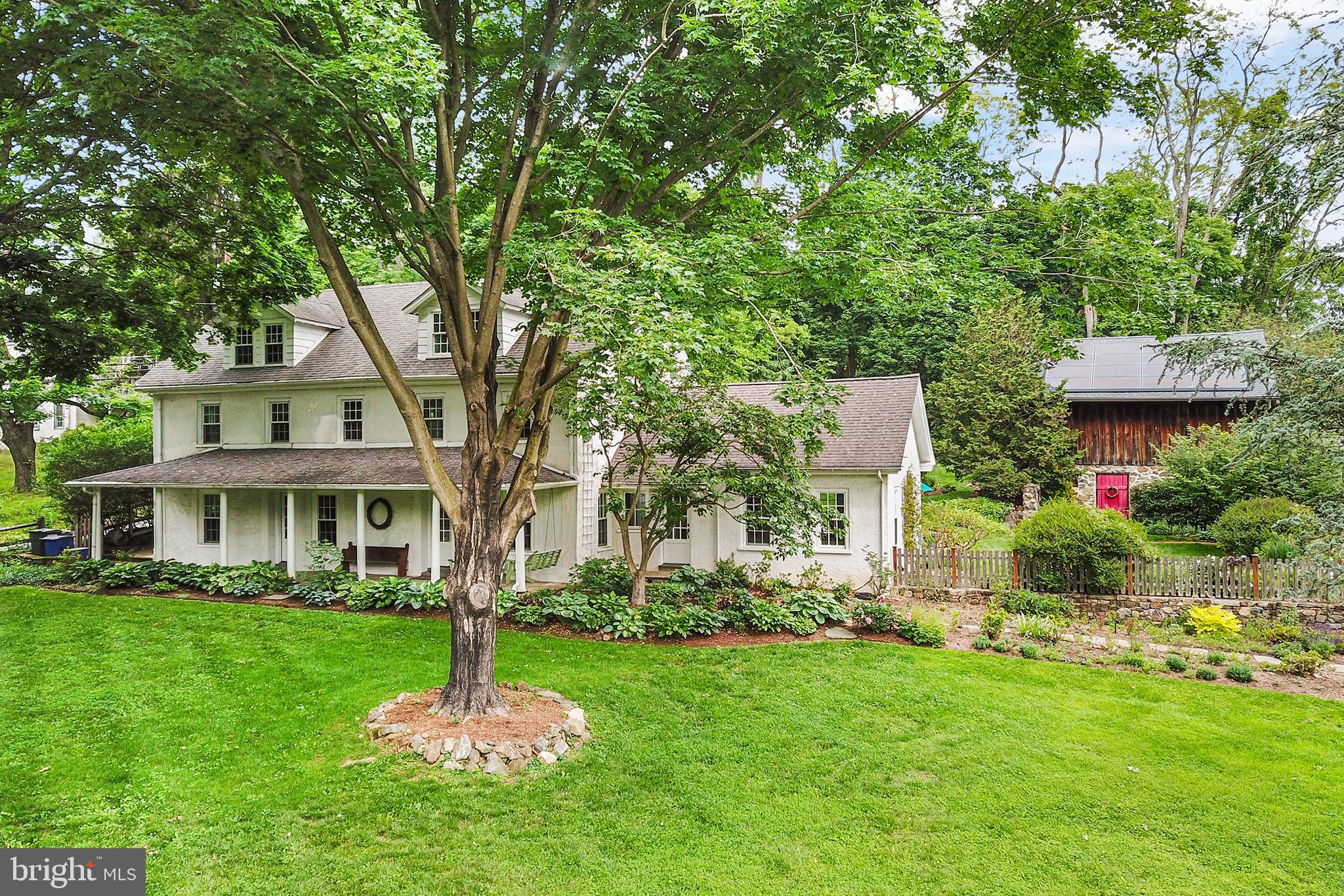 Welcome to "Beakes Land" at 1205 Valley Road, a spectacular William Penn land-grant estate in Glen Mills where three and a quarter centuries of American history meet modern luxury living. Set on 2.2 private acres of picturesque Pennsylvania countryside, this gracious, light-filled 6-bedroom, 3.5-bath stucco-over-stone residence blends timeless 17th- and 19th-century character with contemporary comfort and flexible living spaces for today's lifestyle. Meticulous renovations by Archer & Buchanan Architecture with J. Donovan Construction retained historic integrity throughout, including remarkably thick stone walls, deep window sills, custom molding, and the original 1696 hearth, while thoughtfully integrating modern amenities, including radiant heated Tasmanian oak floors, central AC, and business-grade technology infrastructure. Solar panels and EV charging complete the picture. From the moment you arrive along the winding driveway, mature trees, beautiful landscaping, the covered front porch with swing, and charming barn call you to serenity. The feeling continues within the home’s airy, open first level. The spacious living room features prodigious natural light, wall-to-wall Berber carpeting, and a custom built-in desk with cabinetry. Glass French doors open to the dining area, where sun streams through oversized bay windows offering views of the grounds and access to the fieldstone-walled bluestone patio with oversized concrete sink. Anchored by the original stone fireplace, the adjoining gourmet kitchen boasts custom cherry cabinetry with floor-to-ceiling pantry, honed granite countertops, a soapstone farmhouse sink, deep window seats, Sub-Zero refrigerator, and gas cooktop – a space both architecturally beautiful and functional. Beyond, a vaulted family room addition provides a powder room, laundry facilities, and a sunny living space with built-in bookshelves and Putnam rolling ladder, with French doors opening to the patio and lush courtyard garden, an exquisite setting for entertaining and relaxation. Up one level are four bedrooms, including a primary suite with a well-outfitted walk-in closet, a radiant-heated en-suite bathroom, and French door access to the rear yard. Three additional generously sized bedrooms, one with a playful hideaway,  share a well-appointed radiant-heated hall bathroom. The third floor presents two more bedrooms with charming dormer ceilings, one with a private en-suite bathroom, and the second currently used as a recreation room. It’s an ideal quiet retreat for guests, a home office, or creative pursuits. Outside, the property unfolds as a private sanctuary. The grounds feature classic outbuildings, including a traditional two-story fieldstone and board-and-batten bank barn offering endless possibilities, whether reimagined as a party barn, studio, workshop, or guest suite. Tucked behind the barn is a gated raised-bed vegetable garden. A detached three-car Quaker meeting carriage house and paved forecourt afford ample parking. All are enveloped by lush gardens showcasing seasonal blooms, from winter's hellebores and fragrant paperbush, spring's lilacs and peonies, summer's clematis, iris and lavender, to fall's anemone, sedum and asters. The pear tree, espaliered along the barn front, offers year-round interest. Located within the award-winning Rose Tree Media School District, the property sits equidistant to the shops and fine dining of Media and West Chester, with convenient access to the Media/Wawa regional rail for an effortless commute to Philadelphia. Nature lovers will appreciate adjacent Ridley Creek State Park, Tyler Arboretum, Sleighton Park, and state-protected agricultural and game lands. Whether you are enjoying a quiet morning on the covered porch or hosting gatherings on the expansive bluestone patio, "Beakes Land" is a living piece of American history, offering an unparalleled lifestyle where history began and your future awaits. Schedule your private showing today!