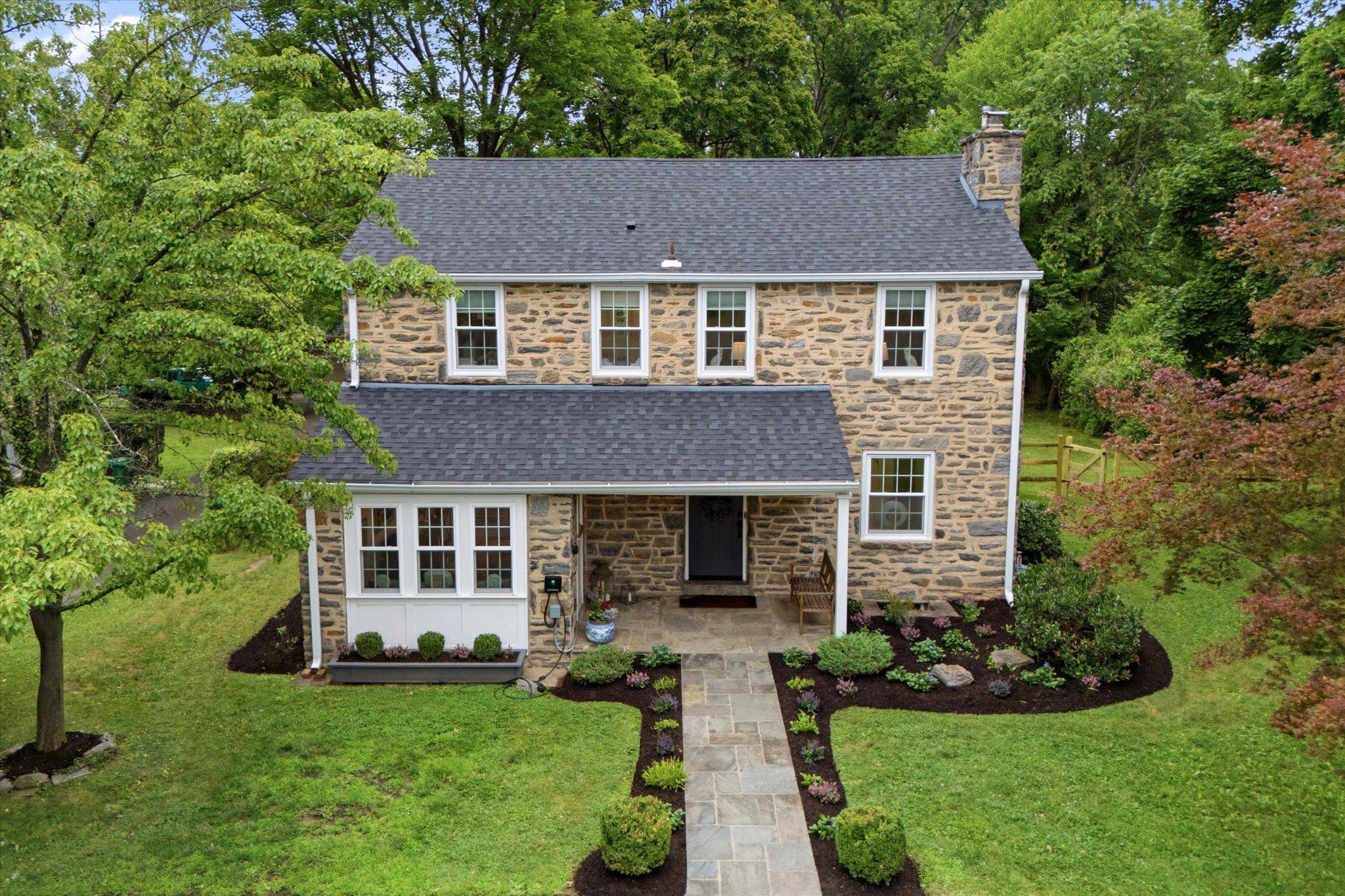 Welcome to this thoughtfully updated and well cared for home in charming Broad Axe Village. This classic stone colonial is set back from the road and has four bedrooms and two and a half baths sitting on nearly half an acre with a large, private, fenced back yard. Enter the home through the covered porch into the living room with a stone surround wood burning fireplace and deep windowsills that opens to the heart of the home: the bright updated custom kitchen with white shaker cabinets, stainless steel appliances and ample counterspace. The dining room is open to the kitchen with storage cabinets and a door to the back covered porch. The mudroom with a bench and large closets connects to the adorable powder room. A flexible den/office space, which could be suitable for work from home, lounging or additional dining space, completes the first floor. Upstairs, the large primary suite includes an en suite updated bathroom. Three additional bright bedrooms and a renovated hall bath complete the second floor. There is an unfinished basement (approximately 500 square feet) that could be finished if extra living space is desired. The flat, fully fenced back yard includes a new large shed for all your storage needs. The shed can be connected to the electric system and includes a wall mounted HVAC unit for possible future use as an ultimate he/she shed, workshop or work from home office space. All house systems are newer (approximately 6 years old), including the roof and gutters, replacement windows, HVAC and plumbing. An electric car charger has been installed, as well. Convenient location close to Prophecy Creek Park and a short distance to the popular shops and restaurants in Ambler, Blue Bell and Chestnut Hill. Award winning Wissahickon schools and convenient location close to Routes 476, 309 and 202. Just unpack and enjoy!