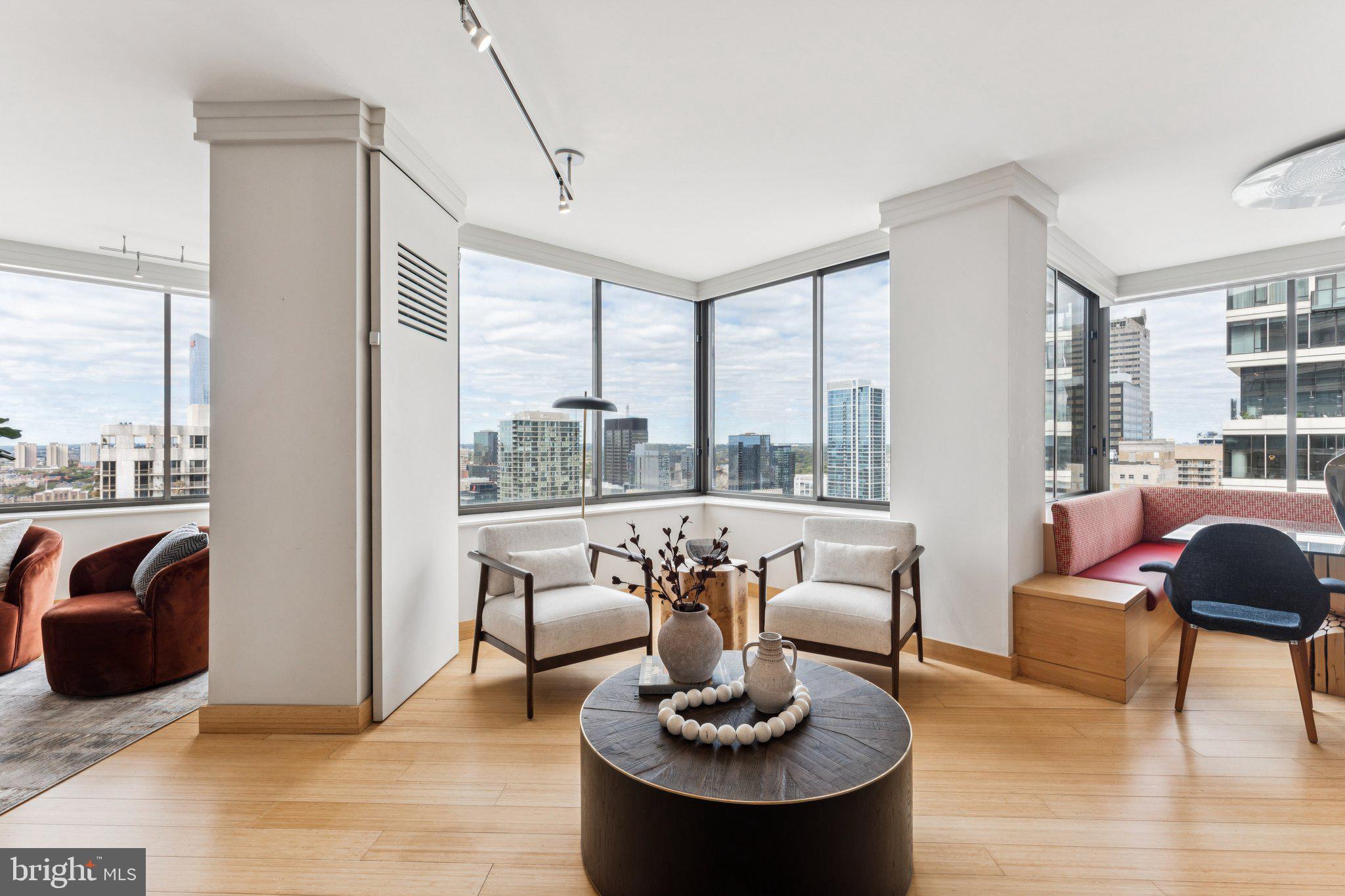Experience the height of sophisticated city living at The Rittenhouse Condominium, where this stunning custom residence enjoys expansive northwestern views that captures golden hour light. Perfectly situated on one of the building’s most desirable tiers, this beautifully renovated home is a rare double-unit combination that seamlessly blends architectural elegance with state-of-the-art smart-home technology—all within one of Philadelphia’s most prestigious full-service addresses.

From the moment you enter, you’re welcomed by an expansive, light-filled living space framed by wide windows that bring in panoramic views and glowing sunsets. The thoughtfully reimagined interior reflects a designer’s touch at every turn, with 6” wide bamboo flooring, curated lighting to highlight artwork, and custom automated window treatments—all managed via integrated iPad technology, which also controls HVAC, lighting, and media throughout the home.

The open-concept living and dining areas offer an ideal layout for both entertaining and relaxed everyday living. A built-in maple banquette anchors the dining space, complete with a bespoke glass table and chairs. The adjacent chef’s kitchen features stainless steel appliances by Dacor, Bosch, and KitchenAid, granite countertops, maple cabinetry, and a breakfast bar perfect for casual dining.

A stylish powder room with marble vanity and an ASKO washer/dryer adds convenience, while a temperature-controlled wine closet offers a curated touch for collectors and entertainers alike.

Originally configured as a three-bedroom home, the residence has been reimagined with two expansive suites, enhancing the sense of openness and flow. The secondary bedroom currently serves as a flexible den or office with custom built-ins and generous storage. The third bedroom—now open to the living area—can easily be enclosed again to suit your needs.

The primary suite is a tranquil retreat, featuring a generous custom 9' x 12' walk-in closet and a spa-inspired en-suite bath clad in Jerusalem limestone and Carrara marble. A frameless glass steam shower with rain shower head and multi-jet fixtures completes this luxurious space.

Life at The Rittenhouse offers a rare combination of luxury, privacy, and world-class service. Residents enjoy 24-hour concierge and doorman services, secure valet parking, and the benefits of a meticulously managed building. For an additional cost, indulge in access to The Rittenhouse Hotel’s premier amenities—including the fitness center, indoor pool, full-service spa, and five-star services like room service, housekeeping, laundry, and exclusive dining privileges at Lacroix, Scarpetta, and The Library Bar.

Outside your door, Rittenhouse Square offers lush green space, boutique shopping, award-winning restaurants, and a vibrant cultural scene—all just steps away.

Whether you're looking for a primary residence or an elegant in-town retreat, this exceptional home offers refined design, smart functionality, and access to Philadelphia’s finest lifestyle in one of its most iconic locations.