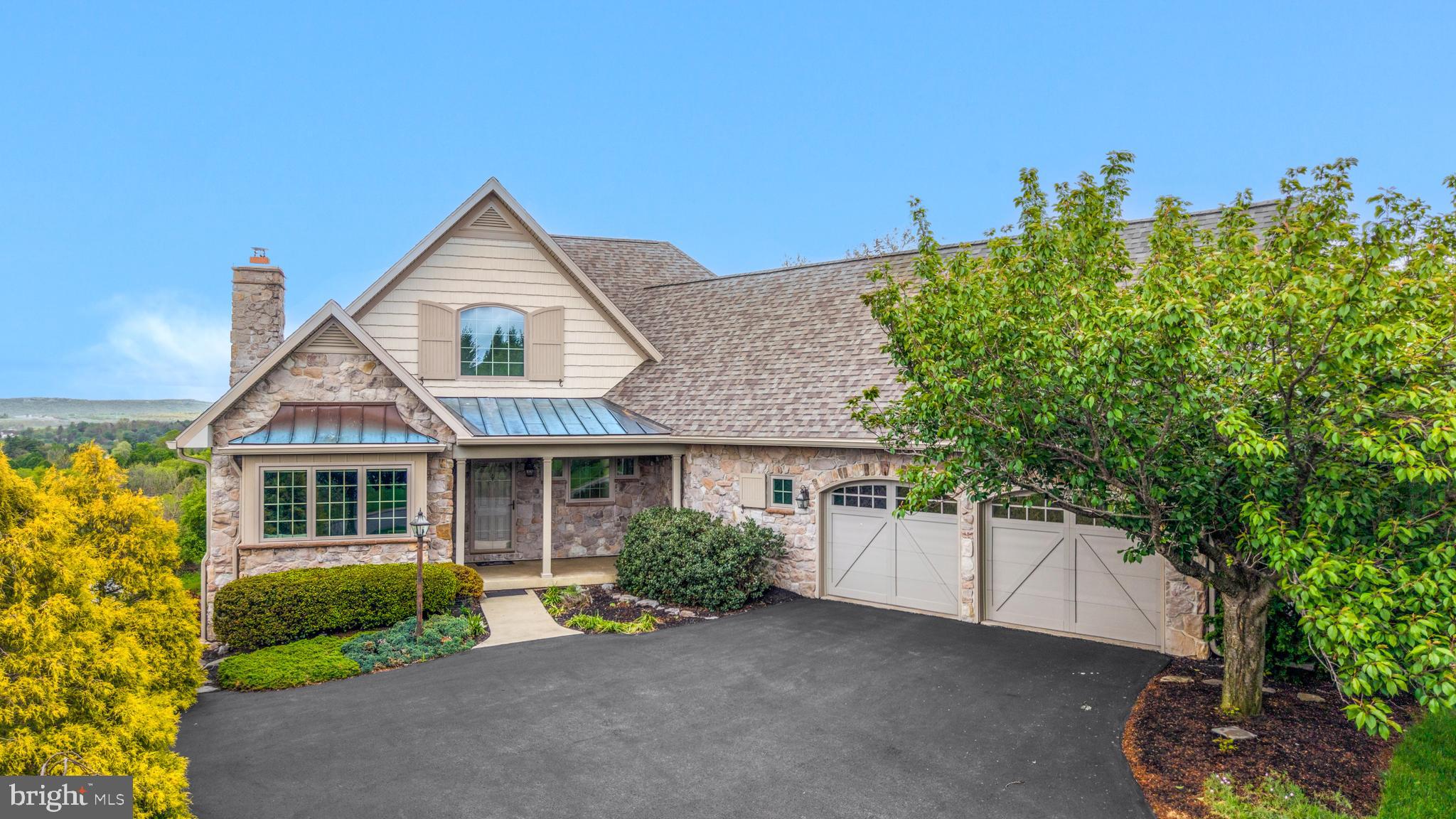 Perched among the beauty of Centre Hills, this thoughtfully designed stone ranch oﬀers timeless charm and cottage-inspired appeal. The living room is framed by direct Beaver Stadium views and a cozy ﬁreplace, creating an inviting gathering space. A true standout, the kitchen oﬀers an exposed brick accent wall, stainless steel appliances, and an island with a prep sink. The dining area connects seamlessly and oﬀers access to the enclosed composite deck — an ideal spot to relax and take in the view. The primary suite features hardwood ﬂoors, a walk-in closet and a private bath with dual sinks and a Jacuzzi tub. An oﬃce with a built-in wall ﬁreplace, half bath and laundry room complete the main level. The lower level adds exceptional versatility, featuring two additional bedrooms and a full bath with an extra shower, ideal for guests or private retreat space. A spacious family room with a wet bar and walk-out patio access enhances the home’s entertaining and everyday living potential. The home has been updated with a brand new roof and newer geothermal system. Enjoy life in the heart of Centre Hills with nearby access to Dalevue Park, Centre Hills Golf Course, shopping, dining, and Penn State.