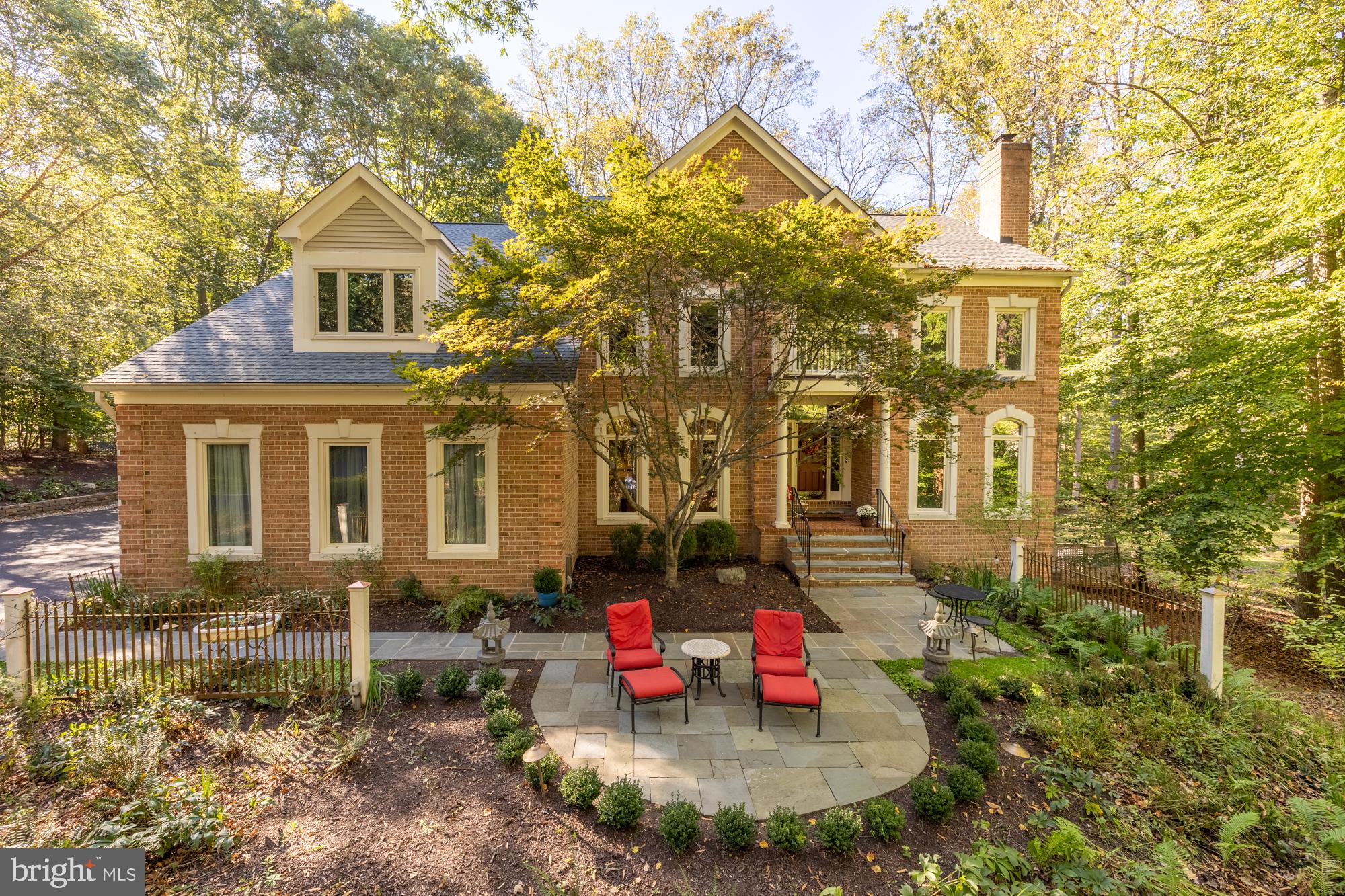 This stunning and meticulously maintained traditional brick home is nestled on just under 2 acres in the highly sought-after community of Great Falls, Virginia. Highlighting impressive three levels, this residence offers an abundance of space and luxurious features that cater to both comfort and functionality.
Upon entering, you are greeted by a grand foyer that sets the tone for the rest of the home. The main floor includes gleaming hardwood floors throughout, formal dining room, a living room with a gas burning fireplace providing elegant spaces for entertaining, a coat closet, an office/wrapping room, a spacious gourmet chef's kitchen, complete with high-end stainless-steel appliances, ample counter space, custom cabinetry, and room for a large kitchen table, making it a dream for anyone who enjoys cooking and entertaining. From the kitchen are sliding glass doors that open onto a well-crafted deck, where the warm sunlight bathes the woods in a golden hue. The deck is equipped with a gas line hook-up, making it easy to enjoy outdoor grilling. The kitchen seamlessly flows into a magnificent great room that showcases a radiant stone hearth with a gas burning fireplace, breathtaking double-story cathedral ceiling, adorned with large windows that flood the space with natural light and a back staircase leading up to the 2nd floor. This inviting area is perfect for family gatherings or hosting friends. The thoughtful design ensures that each room flows into the next, creating a cohesive and welcoming atmosphere throughout the home. To complete this fabulous room are french doors leading you to the spectacular gardens. 
The upper level houses the luxurious primary suite, which is a true sanctuary with a spacious layout with a gas fireplace, 2 walk-in closets, and an updated spa-like primary bath complete with a soaking tub and separate shower. Three additional bedrooms on this floor offer ample space for family or guests, each with its own unique charm and access to 2 well-designed bathrooms.
As you venture to the lower level, you'll discover a versatile recreation room that is ideal for movie nights or game days. This level also features a kitchenette, wet bar, and a fully equipped gym, and access to the backyard gardens allowing you to maintain an active lifestyle without leaving the comfort of your home. Additionally, there is a well-appointed bedroom with an updated en-suite full bath, perfect for guests or as a private retreat.
Outside, the property is beautifully landscaped, featuring multiple gardens that add color and vibrancy to the surroundings. Two flagstone patios provide perfect spots for outdoor dining and relaxation, both of which include a cozy fire pit for gathering around on cool evenings and a water fountain for a serene setting. For those with an active lifestyle, the sports court is a fantastic addition, accommodating both basketball and pickle ball and access to the Potomac Heritage trail that leads to the Potomac River through the backyard making it easy to stay active biking or walking without leaving home.
With a three-car garage, you’ll have plenty of space for vehicles and storage. This home is not just a residence; it’s a lifestyle, offering a perfect blend of elegance, comfort, and outdoor living in one of Virginia's most desirable neighborhoods. Whether you’re hosting large gatherings or enjoying quiet family evenings, this home truly has it all! BE SURE TO CHECK OUT THE DRONE VIDEO!