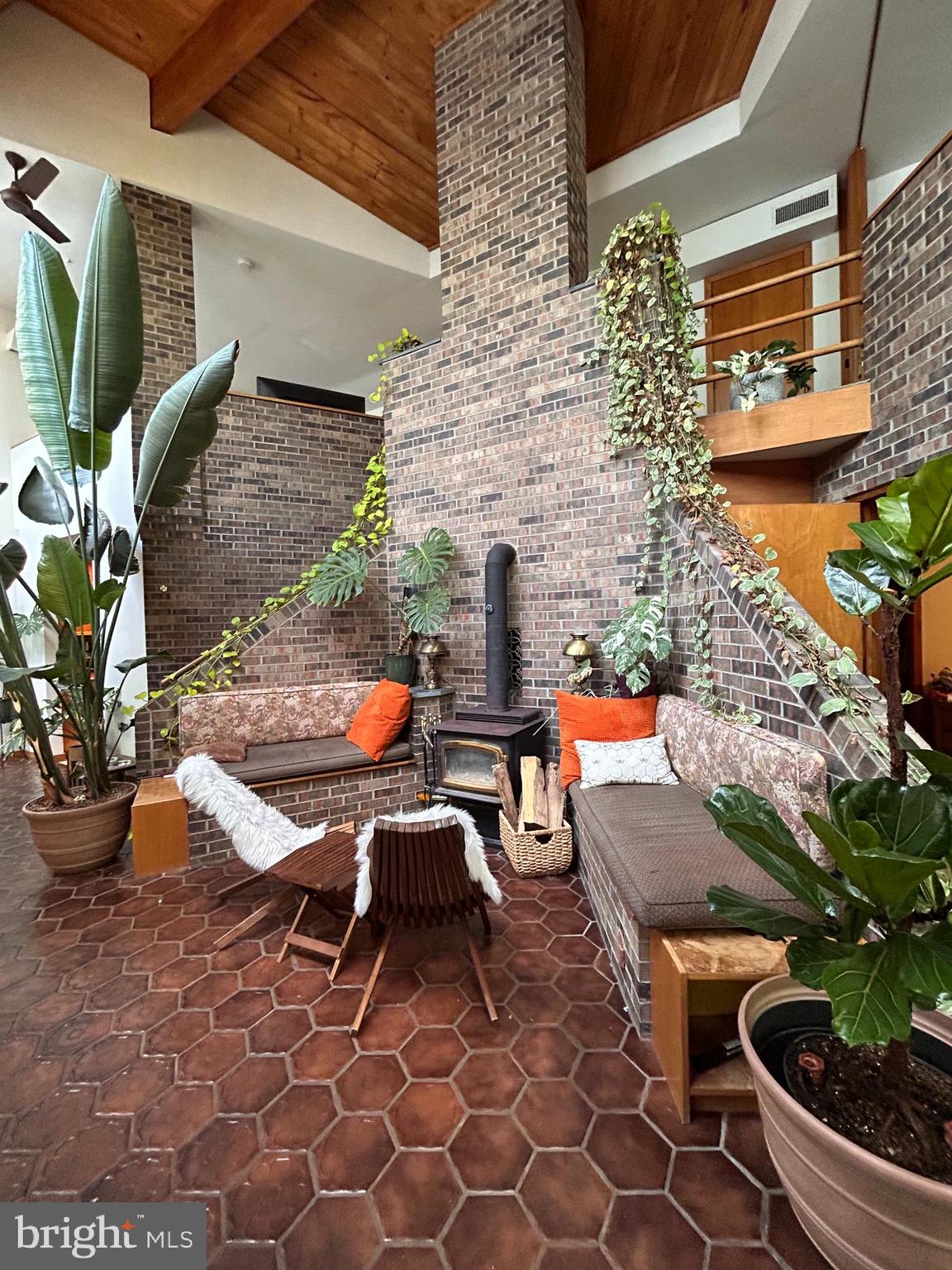 Welcome to a fabulous custom, one-of-a-kind energy-efficient home tucked away on a private three-quarter-acre lot in desirable Elkins Park. The open-concept main living area features floor-to-ceiling windows, front foyer, a wood‑burning stove with built‑in seating, Dining area, the main‑floor primary suite includes two closets and a full bath, onto the spacious eat‑in kitchen that offers an abundant amount of cabinets, granite countertops, a large dining area, stainless‑steel refrigerator & dishwasher, and a laundry/storage room with access to the back yard. The open loft‑style second floor provides two walk‑in closets, a full bath, and two large flex areas, one with a wall of built‑in shelving. Green‑minded features include passive‑solar design and a newly installed gas HVAC system; the property also has a newer roof. Please request the SPD with the list of updates. This home was designed by Alley Friends Architects for owners who love the outdoors and botanical living, this passive‑solar residence offers abundant natural light, multiple living spaces, and exceptional outdoor amenities.  An attached greenhouse/sunroom and outdoor patio expand the living space, the landscaped grounds that include a butterfly garden and a well‑maintained walking bridge over Shoemakers Run Creek.  A detached garage sits at the top of the shared driveway just steps from the main entrance. PLEASE PARK on the street for showings and walk up the pathway to the front door. Important: this home cannot be seen from the street—please respect neighbors’ privacy and do not enter neighboring property's. DO NOT use the driveway for showings.