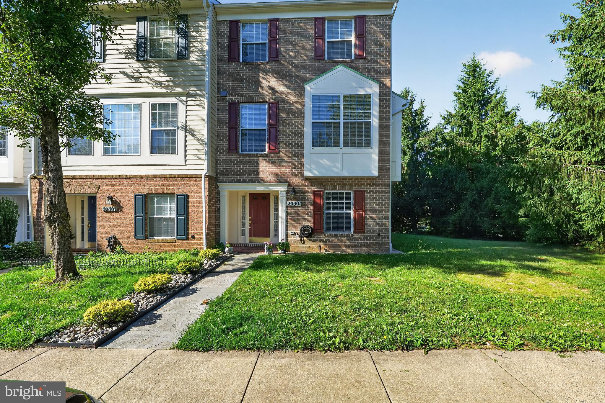 Set on one of the neighborhood's largest lots, this exceptional brick-front end-unit townhouse offers a rare combination of openness with 4 bedrooms, 2.5 bathrooms, privacy, and natural beauty. Mature evergreens and tall trees create a scenic backdrop and enhance the sense of privacy, while a generous stone paver patio anchors the walk-out lower level and a sweeping deck above provides the perfect place to enjoy the changing seasons. Inside, 2,266 square feet of thoughtfully designed living space unfolds across three levels. The main level features a sun-drenched living room with a cozy fireplace, ideal for both quiet evenings and effortless entertaining. The renovated kitchen serves as the heart of the home, showcasing rich wood cabinetry, premium granite countertops, a tile backsplash, and an expanded center island with breakfast bar seating. Hardwood flooring runs throughout the main level, while oversized windows frame tranquil views of the surrounding greenery. Upstairs, three generously proportioned bedrooms feature warm oak hardwood flooring and are complemented by two updated full bathrooms. The walk-out lower level adds exceptional flexibility with a fourth bedroom, a spacious recreation room, and direct access to the private patio and backyard, making it equally well suited for guests, a home office, fitness space, or additional living area. Major updates, including a replaced roof and HVAC improvements, provide added peace of mind for the next owner. The location delivers on every front. Montgomery Village's 335 acres of green space encompass 18 park areas and miles of trails woven throughout the community. Amenities offered through the Montgomery Village Foundation include six pools, 18 tennis courts, basketball, volleyball, soccer and lacrosse facilities, an amphitheater, and dog parks. Everyday conveniences are equally close at hand, with Giant, Safeway, Trader Joe's, Wegmans, and Lidl all nearby, along with multiple shopping and dining destinations. Families will appreciate access to Montgomery County Public Schools. Shady Grove Metro Station is approximately four miles away, while I-270 and the ICC/MD-200 provide convenient access throughout the region. Sale strictly in as-is condition. Don’t miss the opportunity to see this one!!!