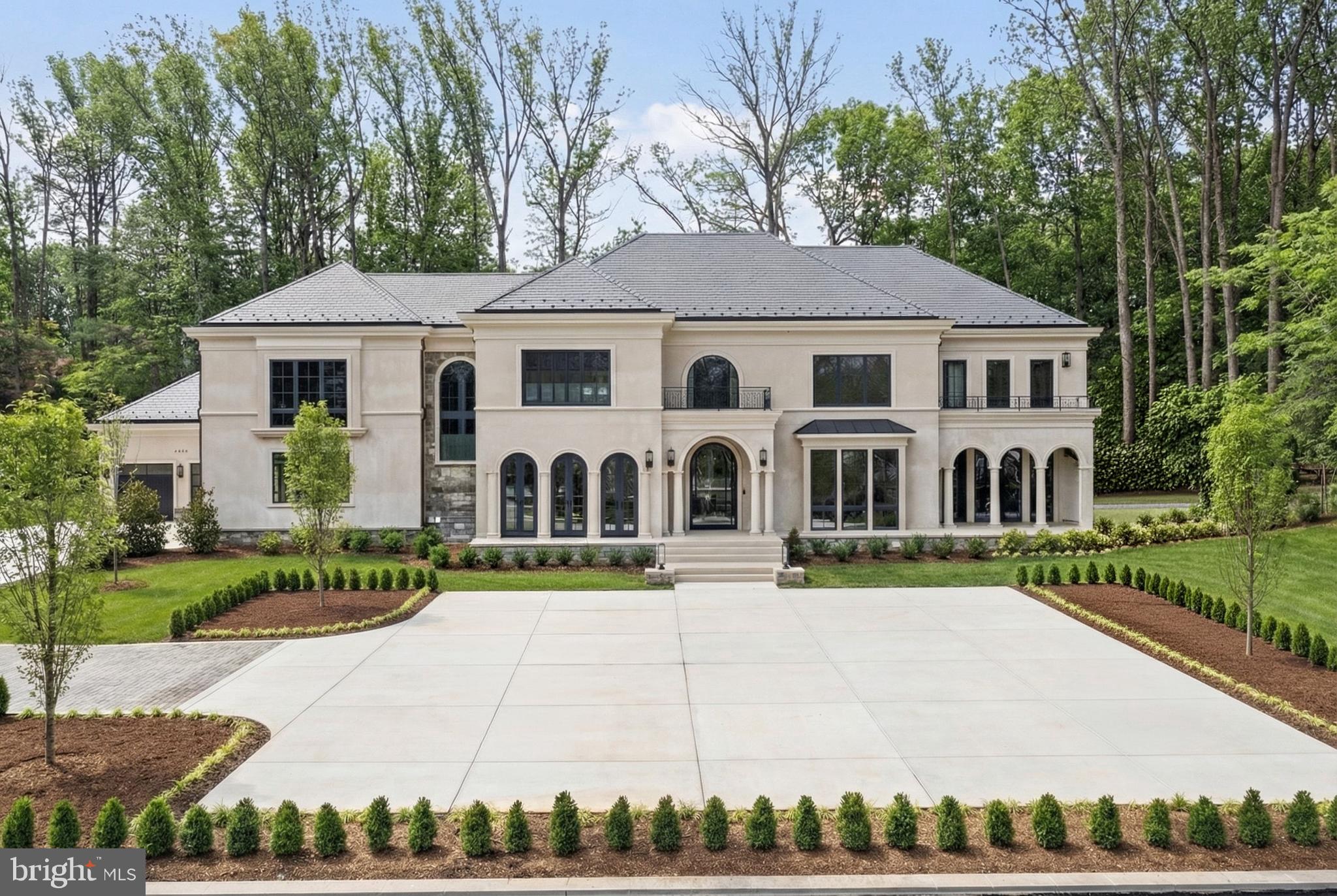 7112 Natelli Woods Lane, a stately new construction designed by GTM Architects. Envisioned as a seamless union of timeless elegance and modern luxury, this 13,000+ square foot estate rests on two sweeping acres of manicured landscape. 

A striking all-glass and steel pivot front door leads into a dramatic foyer, flanked by a formal study and grand dining room. The interiors are defined by bespoke finishes, including 9-foot Barausse Italian doors throughout, custom Italian cabinetry by Stossa Metropolis in the kitchen and bar, and meticulously tailored closets by ARAAN of Italy.

The heart of the home—an exquisite chef’s kitchen with Miele appliances—flows effortlessly into a soaring family room with 22-foot ceilings, setting the stage for refined entertaining. Ambiance is perfected by a state-of-the-art Lutron lighting system, offering over 15 million combinations, paired with custom automated Lutron shades. A butler’s pantry, scullery, elevator, and stylish powder room add convenience.
The main level features a lavish primary suite retreat with a spa-inspired bath, sitting room, and access to a covered porch. Additional highlights include a laundry room, pool bath, and five-car garage. A 30'x15' covered porch with arches, columns, heating, and a dual-sided fireplace invites all-season enjoyment with a view of the pool beyond.

Upstairs, discover five secondary bedroom suites, an optional second primary suite, and a sunlit family lounge overlooking the grounds.

The fully finished lower level is designed for indulgent recreation with a cinema, bar lounge, golf simulator, gym, billiards area, and a private guest suite.