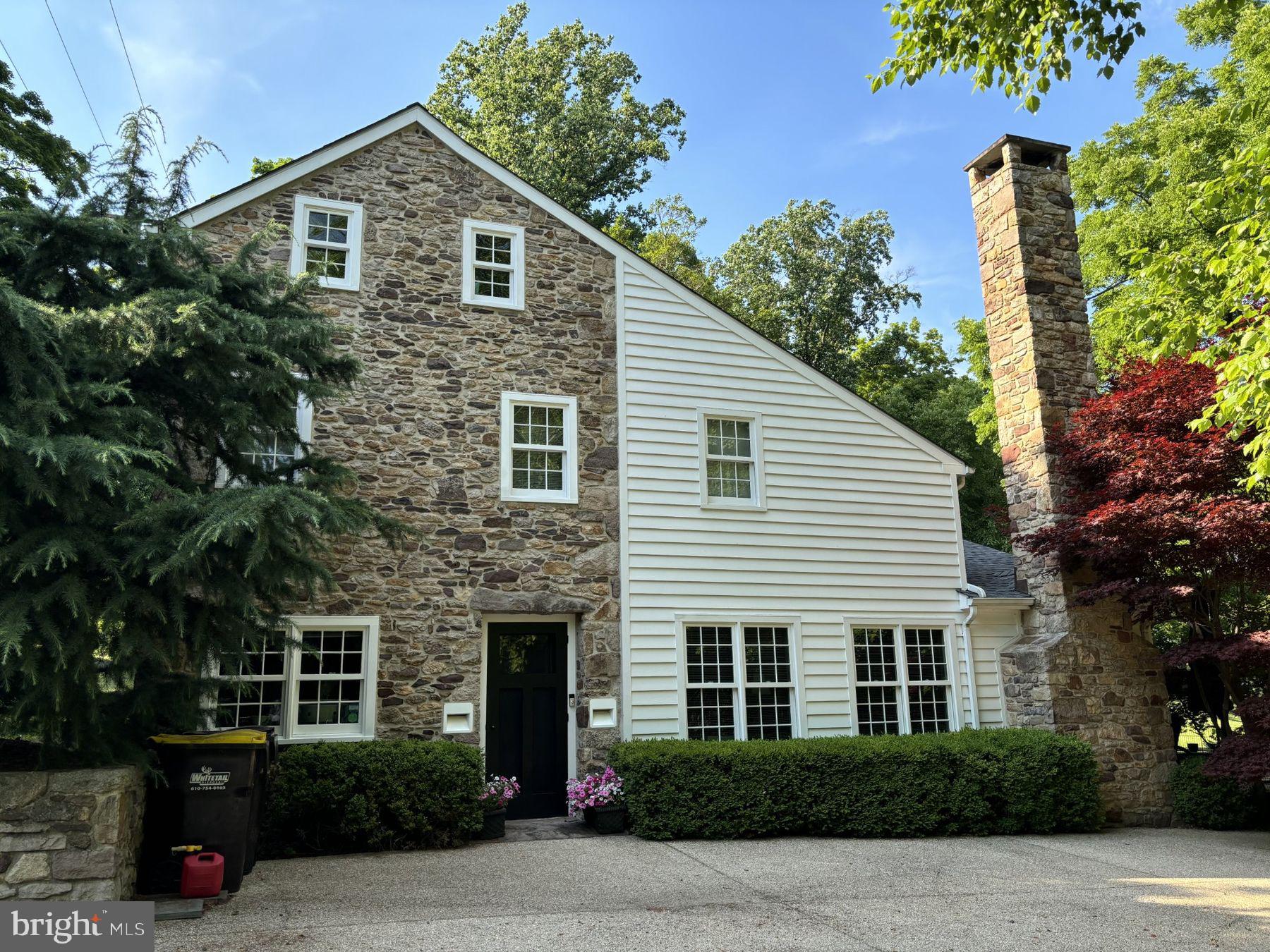 Unassumingly elegant, this completely renovated antique stone home opens to reveal a refreshingly modern interior. Exposed stone walls and radiant heat slate floors throughout the main level set a minimalist background for unique custom lighting and walls of windows. Cook's kitchen offers clean lines of honed black granite counters, interrupted only by a state-of-the-art gas range and stainless steel sink. Cleverly hidden behind a facade matching the surrounding cabinets, the camouflaged Sub-Zero refrigerator is spacious and well-placed. Great room offers an adjacent full bath, fireplace, and dramatic views of the secluded backyard, as well as a floating wooden staircase to the upper level. Upstairs, rustic wood floors blend together the den with wall of built ins, the foyer, and a main bedroom with plenty of light and a full slate bathroom. A third floor bedroom is flexible as well as spacious. Outside, a stone walkway leads from the backyard to the in-ground pool, pool house. Ideal for entertaining.