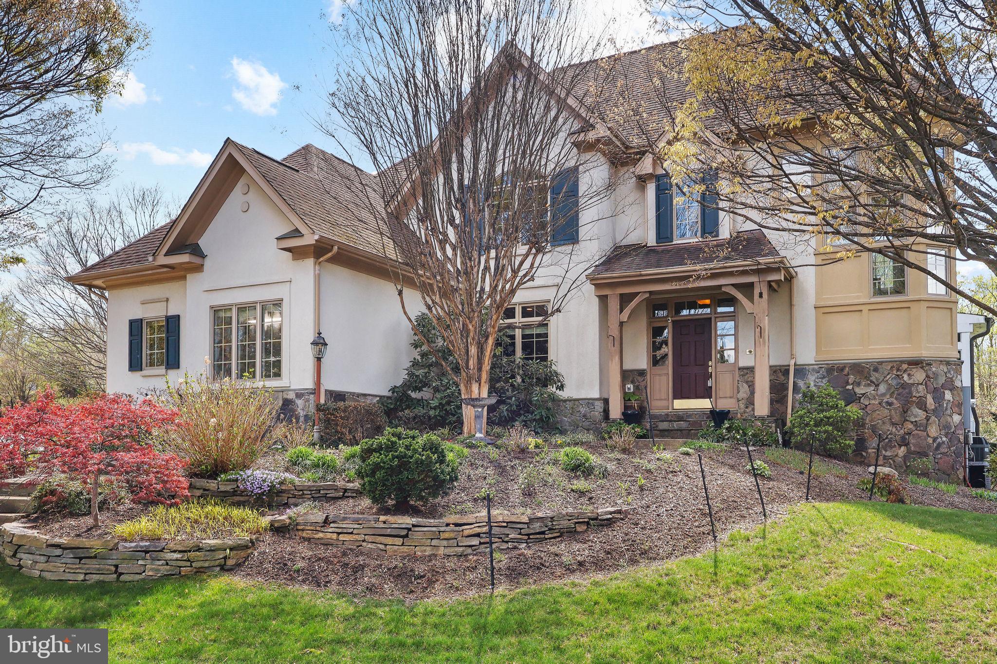 A rare opportunity in Vienna—this exceptional stucco and stone residence blends timeless design, luxury upgrades, and a fully finished walk-out lower level built for elevated everyday living. Located in the Langley High School pyramid and just minutes to Tysons, McLean, and major commuter routes, this home offers the ideal balance of privacy, convenience, and lifestyle.

From the moment you enter, you’re greeted by expansive living spaces, abundant natural light, and a seamless, open flow designed for both everyday living and entertaining. The main level is anchored by an oversized eat-in kitchen featuring extensive custom cabinetry, granite countertops with full-height backsplash, stainless steel refrigerator, double wall ovens, a gas cooktop with custom wood hood, and a large center island with seating. The kitchen opens effortlessly to a sun-filled breakfast room surrounded by walls of windows and direct access to the screened-in porch, creating a bright and inviting space that blends indoor and outdoor living. The main level also features a family room with gas fireplace and blower. Additional main level highlights include a formal dining room with coffered ceiling, and a dual-sided gas fireplace shared between the living room and formal dining room, creating a warm and inviting atmosphere across both spaces, a laundry room, and a flexible sunroom with coffered ceilings that can easily serve as a main-level bedroom with access to a full bath. A private office with custom built-in bookshelves, desk, and filing drawers provides an ideal work-from-home setup.

Upstairs, the primary suite offers a true retreat experience with a tray ceiling, gas fireplace, and a Juliet balcony with glass pane double wood doors that fill the room with natural light. The suite is complemented by an expansive custom walk-in closet with built-in organization. The spa-inspired primary bath is finished with high-end stonework and features a soaking tub set within a wall of windows, a large glass-enclosed shower with multiple shower heads, dual vanities with ample storage, and radiant heated floors for year-round comfort. Additional upper-level bedrooms are generously sized and offer flexible living options for guests, office space, or family needs.

The fully finished walk-out lower level truly lives like a second home, offering two bedrooms and two full bathrooms along with a large recreation room with coffered ceilings, a fully equipped wet bar with granite countertops, cabinetry, and built-in appliances, including an ice maker capable of producing approximately 40 pounds of ice per day. This level also includes a dedicated home theater room, fitness area, and multiple flex spaces, with walk-out access bringing in natural light and connecting seamlessly to the outdoor living areas.

Outdoor living is equally impressive, highlighted by a screened-in porch with a wood ceiling and ceiling fans, built with premium Pau Lope Brazilian hardwood known for its durability and resistance to the elements. The property is enhanced by extensive hardscaping including stone pathways, tiered walls, and mature landscaping, along with a full irrigation system. A rare HOA-approved storage area beneath the deck adds functionality, with structural support strategically placed to improve the view of the patio.

Additional features include multiple gas fireplaces, central vacuum, multi-zone audio wiring throughout, reverse osmosis water filtration, upgraded HVAC systems with humidifiers and air purification, improved insulation and air sealing, and a long-life 50-year architectural roof installed in 2011. The home is also equipped with a 74-gallon quick-recovery water heater, providing added efficiency and capacity for everyday living.

This home offers an exceptional combination of space, craftsmanship, and location in one of Northern Virginia’s most sought-after communities.