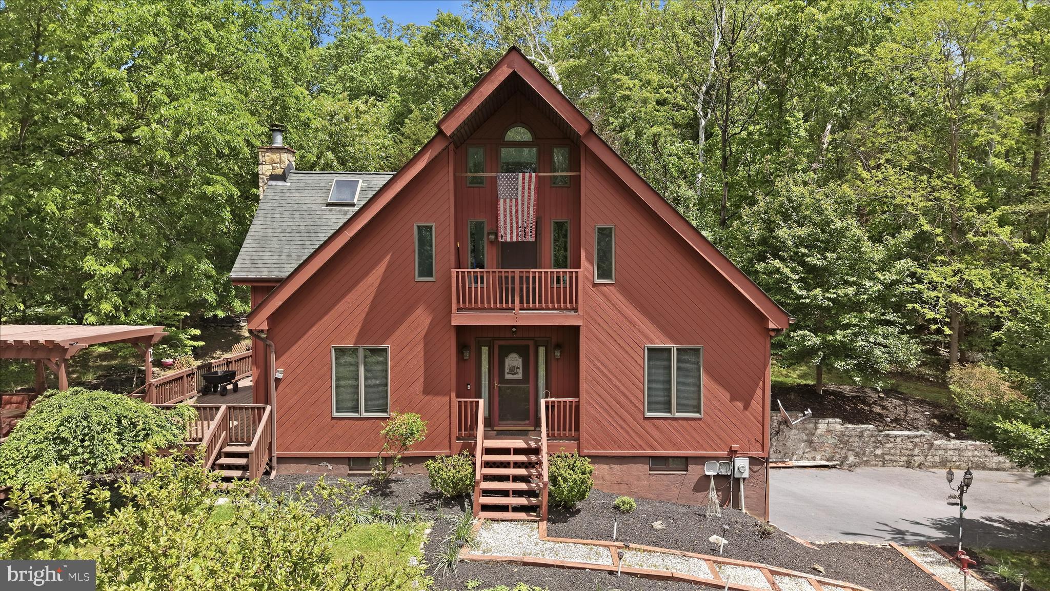 Tucked into a peaceful, cabin-style setting near the Shenandoah River, 54 Sumac Ln offers a rare opportunity with 1.79 acres across multiple lots, blending privacy, space, and year-round comfort. This 3-bedroom, 2-bath home features a spacious, light-filled main level with soaring ceilings, skylights, and a cozy fireplace in the living room, opening seamlessly to the dining area and kitchen—perfect for everyday living and entertaining. The kitchen is equipped with granite countertops and ample cabinetry. Two bedrooms and a hall bath complete the main level. Upstairs, the spacious primary suite boasts high ceilings, skylights, a walk-in closet, en suite bath with laundry, and private access to a balcony deck. Outdoor living is a highlight with an expansive deck plus a separate covered section, ideal for relaxing or hosting while enjoying the wooded surroundings. A 2-car attached garage and generous driveway parking add convenience. 
For those seeking even more space and direct water access, an additional 2.45-acre riverfront parcel is available for purchase separately.
Just minutes from hiking trails, the Shenandoah River, historic downtown Harpers Ferry, and major commuter routes. Schedule your showing today!
