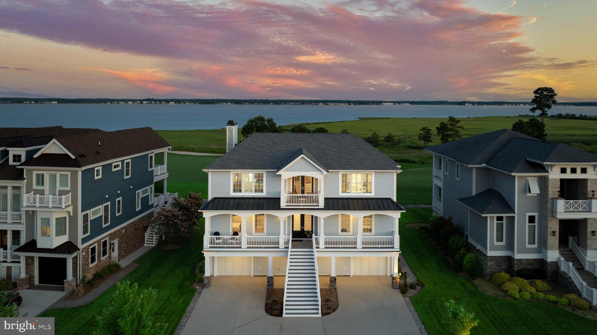 Within the prestigious Sanctuary section of The Peninsula on the Indian River Bay, 27668 Sterling Boulevard presents an extraordinary opportunity to experience one of Delaware's finest luxury golf and waterfront residences. Perfectly positioned on a premium golf-front homesite overlooking the 7th green, this exceptional three-story home, with a private elevator, captures breathtaking panoramic views of the Indian River Bay, the inlet, and the manicured fairways beyond. Multiple balconies, a screened porch, and an expansive paver patio create exceptional outdoor living spaces where bay breezes, spectacular sunsets, and picturesque golf course vistas become part of everyday life.

Inside, sophisticated coastal elegance meets timeless craftsmanship. Wide-plank engineered hardwood flooring extends throughout the second and third levels, while an inviting foyer opens to a beautifully designed floor plan. Rich architectural details, including extensive crown molding and elegant coffered and trayed ceilings, create a refined yet welcoming atmosphere. The inviting living room is anchored by a gas fireplace flanked by custom built-ins and a wall of sliding glass doors that seamlessly blend indoor and outdoor living while framing the spectacular waterfront setting.

Designed for both entertaining and everyday living, the gourmet kitchen showcases an expansive center island with seating, crisp white Craftsman-style soft-close cabinetry with display cabinets, a five-burner gas cooktop beneath a custom range hood, Bosch double wall ovens with a built-in microwave, a classic subway tile backsplash, and premium finishes throughout. A custom built-in banquette offers the perfect spot for morning coffee or casual dining while taking in the surrounding views. The adjoining wet bar, complete with a beverage refrigerator and sink, enhances entertaining, while the elegant dining area provides a beautiful setting for more formal gatherings.

The main living level also offers a private guest suite with an ensuite bath, a home office with custom built-ins, a powder room, and direct access to the screened porch and balcony.  The upper level is dedicated to luxurious comfort. A spacious family room provides an additional gathering space, while the primary suite offers private balcony access overlooking the golf course and bay, a spa-inspired bath with dual vanities, a soaking tub, a walk-in shower w/bench seating, and a custom walk-in closet. Two additional bedrooms, each with private ensuite baths, provide exceptional comfort and privacy for family and guests.

The entry level is designed for recreation and entertaining, featuring a spacious recreation room with a custom wet bar and beverage refrigerator, a convenient powder room and a versatile flex room ideal for a home gym, hobby space, or an additional bedroom. Step outside to your private resort-style retreat where a paver courtyard features a built-in grilling station, hot tub, fire pit, raised seating walls, and sweeping views of the championship golf course and Indian River Bay. It is the perfect setting for entertaining or simply relaxing after a day on the course or the water.

Additional highlights include two tankless water heaters, Andersen hurricane-rated windows and doors, a partial-house backup generator, an irrigation system, a surround sound system, and an oversized two-bay garage with a tandem bay designed to accommodate another vehicle, kayaks, paddleboards, bicycles or just perfect for extra storage!  Life at The Peninsula is equally extraordinary. Residents enjoy one of Delaware's premier private resort communities, highlighted by the Jack Nicklaus Signature Golf Course, indoor and outdoor pools including a wave pool and adults-only oasis, a full-service spa, state-of-the-art fitness center, tennis, pickleball, basketball, mini golf, a private bay beach with kayak and paddleboard access, miles of scenic walking trails through an Audubon Certified Nature Preserve, and fish pier.
