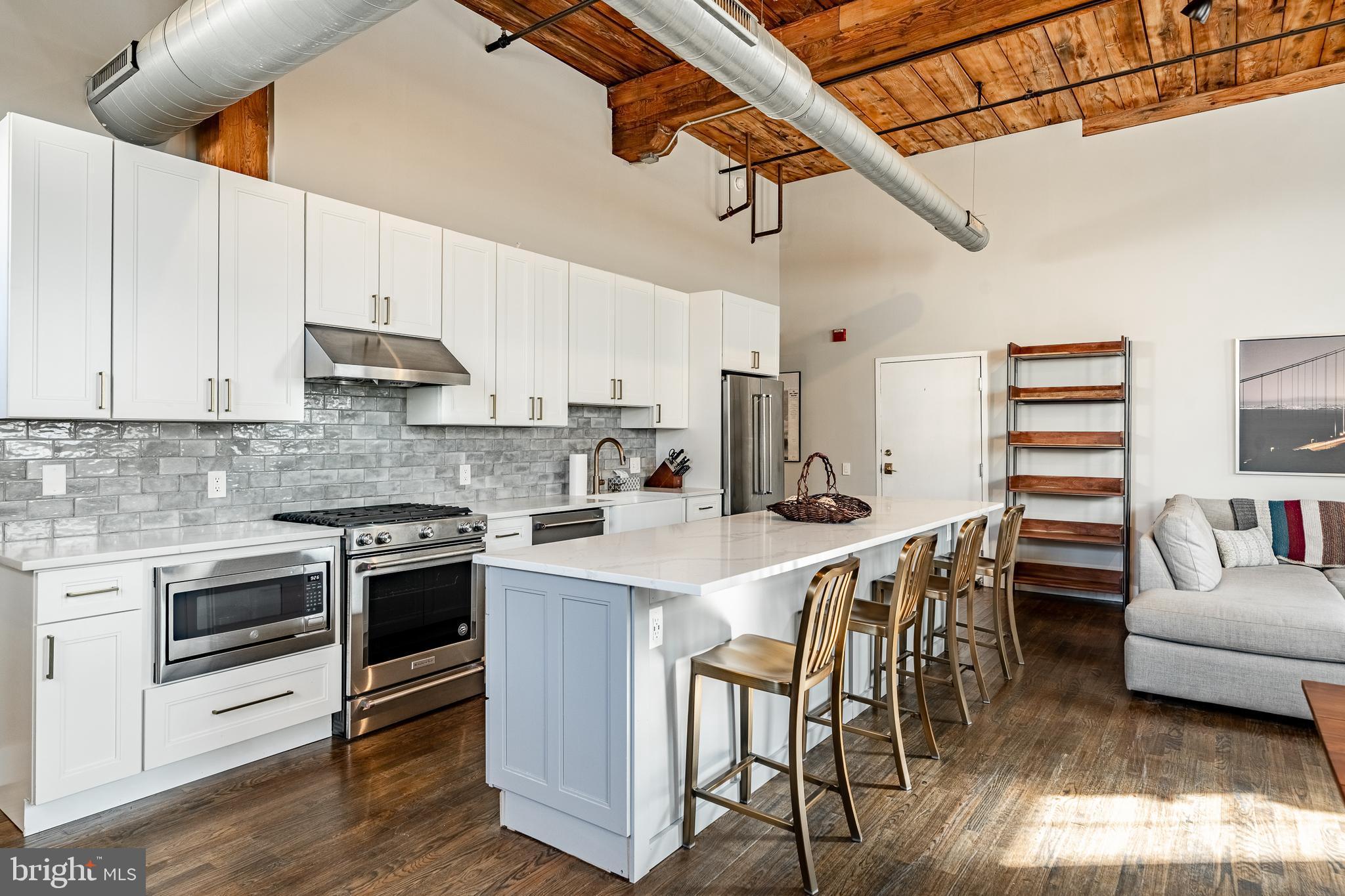 This stunning 2BR / 1BA loft, meticulously renovated by its previous home builder & designer/owner, is ideally situated just a few blocks from the heart of Manayunk’s Main Street. Housed in a historic textile mill, this exceptional space combines contemporary design with industrial features, offering a rare and stylish living experience. As the standout unit within the 9-unit Felt Works building, it boasts its own private entrance, direct access to secured, climate-controlled parking at the rear, and a generously open living space.

Inside, you'll be captivated by 20-foot ceilings, large arched windows, exposed brick and stone walls, and freshly refinished oak floors that flood the loft with natural light. The open concept kitchen is a true centerpiece, featuring an oversized 11-foot island, sleek Calcutta quartz countertops, and classic white shaker cabinetry. Equipped with premium KitchenAid appliances, including a farmhouse sink and gleaming brass fixtures, this kitchen is designed for both function and style. The open-concept layout allows for flexible use of the space and creates an entertainers dream. 

The master bedroom offers ample space for a king-sized bed and includes two closets, one of which is a spacious walk-in. The second bedroom provides plenty of options depending on your needs, making it perfect for a home office, guest room, or nursery. The newly updated bathroom features dual entry, from both the master and the hallway, for added convenience. It includes a combined shower and tub, a 60-inch double-sink vanity, and a laundry/linen closet. Stylish shiplap walls, exposed beams, and brass accents add to the loft’s refined design.

The home is outfitted with high-end details throughout, including solid wood doors and trim. Located just steps from Manayunk’s best dining, shopping, and trails, with a quick 15-minute drive to downtown Philadelphia, this loft offers the perfect balance of historic character and modern luxury. A must-see property!