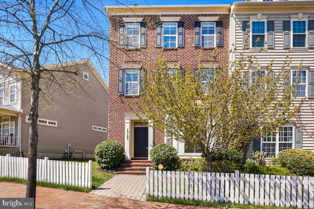 Welcome to 13123 Clarksburg Square Rd.! This stunning east-facing brick end-unit townhome is located  the desirable Clarksburg  Town Center Community! At over 2,600 square feet of living space on 3 levels, this is one of the largest 3 level townhome floorplans in Clarksburg. The home has 3 bedrooms and 2.5 bathrooms with a detached 2 car garage. The main level boasts durable 16" porcelain tile flooring throughout with high 10' ceilings and a formal dining room. The open concept kitchen overlooks the family room and breakfast area. The kitchen is upgraded with high end granite countertops, custom cabinetry, stainless steel appliances, and huge island with breakfast bar seating for four. The family room includes a cozy gas fireplace and a walk-out to the maintenance free deck and fully fenced backyard with access to the two-car detached garage, with tons of storage space. The second level includes a private primary bedroom suite with a grand double door entry and a huge walk-in closet. The spa like ensuite bath renovated in 2020 includes a dual sink vanity with quartz countertops, freestanding soaking tub, and a gorgeous walk-in frameless glass and tile shower with rain showerhead. This level also includes a dedicated laundry room and a sitting room ideal for a home office or flex space. The top level includes an additional family room, 2 generously sized bedrooms and a full bath. Updates include Primary Bath renovation and new hot water heater in 2020, New HVAC and roof in 2024, all new carpet, new rear exterior door and fresh paint in 2025. Behind the garage is a tot lot and courtyard, perfect for spending time with little ones outside. Prime location walkable to shops and restaurants. Easy access to major commuter routes and public transit. Community amenities include swimming pool, playgrounds, walking paths, and more. Schedule your showing today!