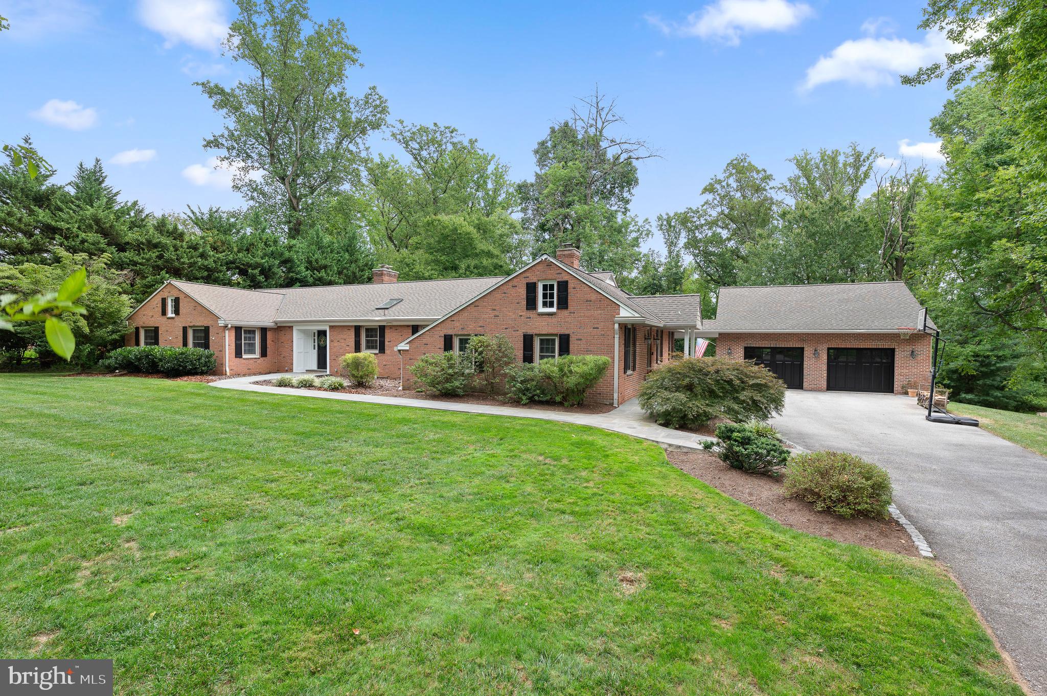 Introducing your forever home, a stunning expanded ranch-style home in Easttown Township, set on 1.3 acres of beautifully landscaped, flat, and private land. This brick facade residence combines timeless elegance with modern convenience, creating an ideal living environment for family times as well as entertaining. As you approach from the flat driveway, you are greeted by beautiful bluestone walkways that connect the welcoming front door, side covered porch, rear covered patio, and the oversized 2-car garage. Upon entering, the spacious foyer leads to a living room with a large picture window that showcases breathtaking views of the expansive rear yard, a sight that captivated the current owners at first glance. To the right of the entryway, the well-appointed eat-in kitchen seamlessly flows into the dining room with French Doors to the large, covered patio and an expansive sunken family room, the heart of the home. This light-filled space features large windows that overlook the serene backyard and has exquisite millwork, a floor-to-ceiling stone wood-burning fireplace, a wet bar with additional butler pantry storage, and a private powder room. A door from the family room opens to a covered rear patio, ideal for al fresco dining and entertaining in the private, picturesque backyard. The home is thoughtfully designed for both entertaining and practicality with mudroom cubby storage, a spacious laundry room featuring a utility sink and extra storage, as well as a private home office conveniently located near the side entrance. The private bedroom wing offers a tranquil retreat, with ample closet space and easy access to the magnificent primary suite. This luxurious suite includes multiple walk-in closets, a dressing area, a large linen closet, and a sumptuous primary bathroom with a jetted tub, oversized stall shower, and a double vanity with extensive storage. A private covered porch off the suite provides a serene setting for morning coffee or evening relaxation. Additional accommodations include a large bedroom with an ensuite bath (the original owner's suite), a beautifully updated hall bathroom with an oversized double vanity, a spacious stall shower, and two more bedrooms. All closets are outfitted with custom systems for optimal organization, and attic storage is easily accessible via walk-up steps. The lower level of the home offers unparalleled versatility, featuring a music room that could serve as a fifth bedroom or home office, a full bathroom, and expansive spaces for recreation, entertainment, or a dance studio. With both finished and unfinished areas and a crawlspace, storage is abundant. Walk-up steps to the rear yard provide convenient access for future projects, such as adding a pool to this private oasis. The oversized detached garage provides ample space for two cars, additional storage on the garage floor level, and a fully floored attic above, accessible via walk-up steps and connected to the house by a covered passageway. This property represents a rare opportunity to own a beautifully maintained home that blends classic charm with modern amenities in a serene, private setting and with one-floor living, you will never need to leave! Schedule your private showing today to experience all this exceptional property has to offer.