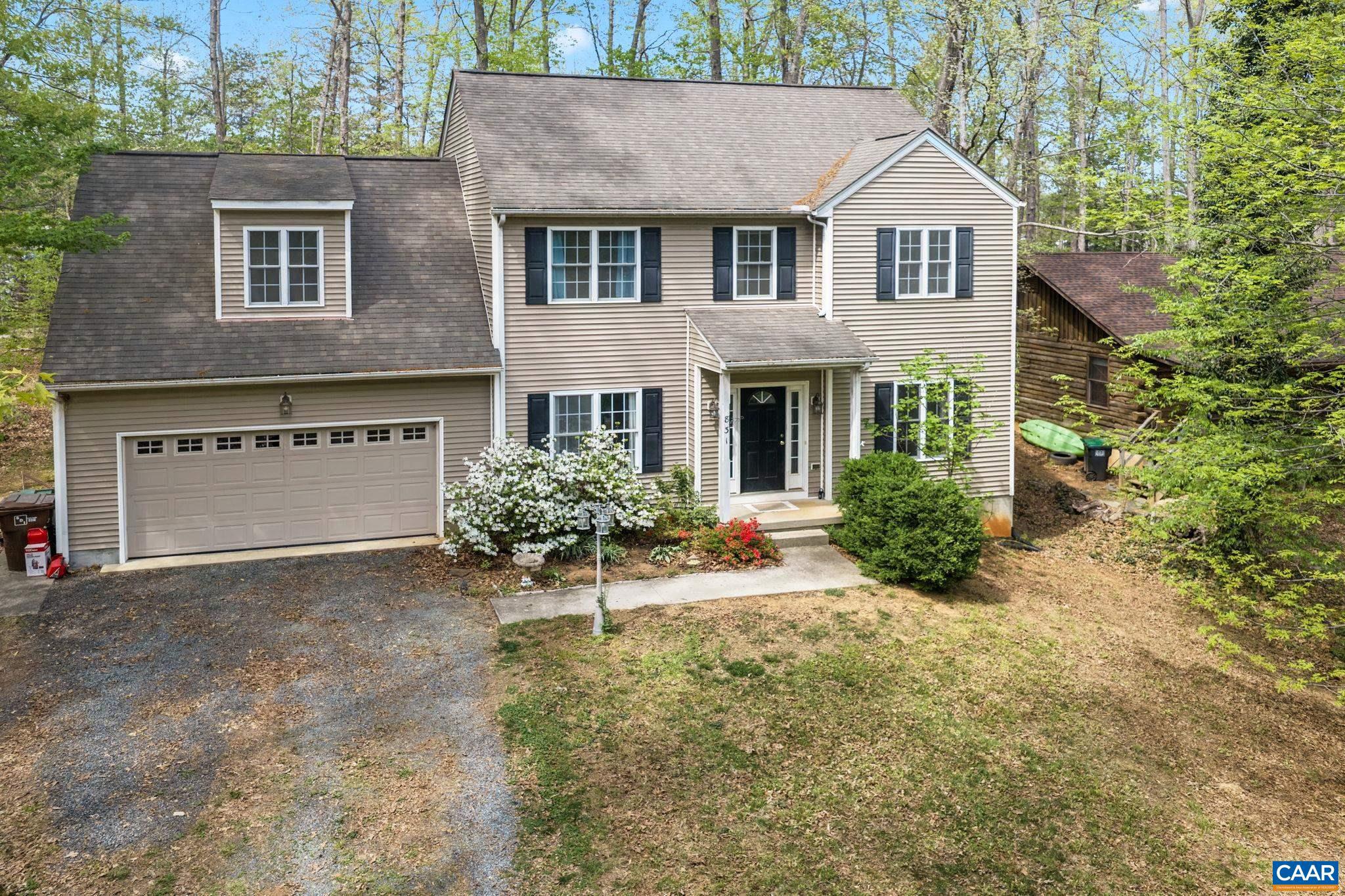 Incredible value! Priced significantly under tax assessment, this Lake Monticello colonial is conveniently located near the main gate. The main level offers wood flooring throughout, a spacious living area with a gas fireplace, a separate dining room, and a kitchen that opens to a breakfast area. A rear deck off the kitchen overlooks a level backyard. Upstairs, the primary bedroom includes a walk-in closet and private bath. Three additional bedrooms offer flexible use, including one oversized room that could function as a bonus room or additional living space. A walk-up attic with permanent stairs provides substantial storage. Located within walking distance to community amenities including the pool, clubhouse, and tennis courts.,Wood Cabinets,Fireplace in Living Room
