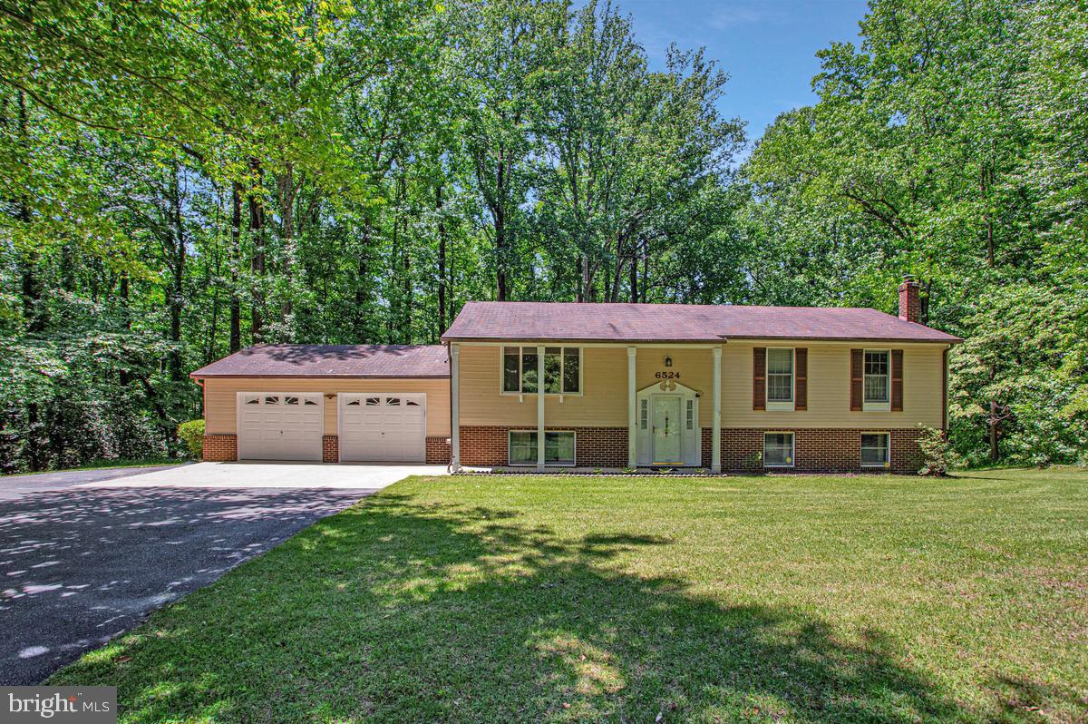 Highly coveted opportunity in the sought-after Wooded Valley community, where homes are seldom offered for sale.  Nestled on a picturesque 2-acre homesite with a sprawling front and backyard, circular driveway, and mature landscaping.  This estate property presents a unique opportunity to create your dream home in one of Southern Anne Arundel County's most desirable neighborhoods.
Designed with a traditional and functional layout, the main level offers 3 bedrooms and 2 full baths, along with generous living spaces ideal for both everyday living and entertaining. The kitchen serves as the heart of the home, seamlessly connecting to the adjoining dining room and inviting family room. Sliding doors open to a spacious rear deck overlooking the expansive tree-lined backyard, creating a peaceful setting for morning coffee, outdoor dining, and gatherings with family and friends.  The green house offers additional space for garden enthusiasts. 
The lower level provides exceptional flexibility with a fourth bedroom or home office, full bath, and an oversized recreation room anchored by a cozy gas fireplace. A large laundry and utility room offers abundant storage, while the oversized two-car garage provides ample space for vehicles, hobbies, tools, and outdoor equipment.
A standout feature of the property is the approximately 13' x 26' bonus room addition located beneath the deck. Whether envisioned as an artist's studio, fitness room, workshop, guest retreat, in-law suite, or private workspace, this versatile area offers endless possibilities to suit your lifestyle.
Known for its spacious lots, established homes, and peaceful surroundings, Wooded Valley offers the best of both worlds—privacy and convenience. Ideally located within easy reach of Annapolis, Joint Base Andrews, Washington, D.C., Northern Virginia, and major commuter routes, residents enjoy a tranquil setting while remaining close to shopping, dining, marinas, parks, and the many amenities of Southern Anne Arundel and Calvert Counties.
Being sold as part of an estate and offered strictly As-Is, this property presents an exceptional opportunity to renovate, personalize, and build equity in a neighborhood where opportunities are few and far between.  With generous square footage, a premium lot, timeless potential, and an unbeatable location, 6524 Wilson Road is ready for its next chapter.
