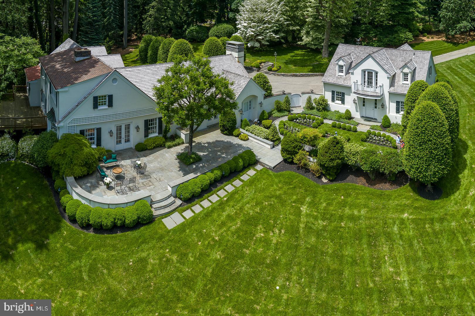 Extraordinary residential compound in the utmost private location, with a long, elegant tree-lined drive and remarkable grounds of nearly three acres with gorgeous views. Located on one of Villanova's most exclusive and sought after cul-de-sacs, timeless landscape architecture enhances this classic Main Line setting which began with a pedigree from the renowned Philadelphia residential architect, Walter Durham.

Enter the front door to the tiled entrance foyer, with 'straight thru' views and abundant natural light.  Foyer opens to a gracious transverse center hall, with a traditional colonial floor plan, and flows to the formal living room, dining room and library, all with beautiful, random-width hardwood floors.  Foyer flows to the fabulous butler's pantry and wet bar, which open to the magnificent kitchen and great room addition. 

Enter the  white on white island kitchen, which opens fully under a lighted, parabolic archway to the great room with fireplace. Kitchen and great room have double doors out to the flagstone patio and courtyard garden.  Kitchen has pretty hardwood floors, double wall ovens, Sub Zero refrigerator, electric cooktop, twin sinks at a double corner kitchen window with astonishing views out over the patio, and green, granite countertops.  There is a small kitchen desk with seating with built-in shelving units for printer.

Relax in the sun-filled adjacent great room with unique architectural design and wonderful open flow off the kitchen with vaulted ceiling, gas fireplace, flat screen TV with sound system, beautiful millwork, moldings,  hardwood floors, views of the private drive and stunning landscaped grounds. It is here where classic luxury is felt and lived but is never showy. 

Main floor owners' bedroom suite is just off the library and hall, pronounced by the lighted rotunda. This beyond-first-class, ultra-private luxe suite has H/H bathrooms, extensive closet systems, a walk-out door to the raised deck, and hideaway access to the Library and fireplace for true, one-level living at its finest.

Just off the entrance hall foyer are the stairs to the second floor landing. Here are three bedrooms, generous in size and scale. The first bedroom has an en suite full tile bathroom, closet and pretty windows. Bedrooms two and three share a full hall bathroom.

The walk out, partially finished lower level is currently in use as a WFH office and sitting area with WTW carpeting.   Office connects to the full laundry room and to storage and mechanicals rooms. Mechanicals include a whole house, back -up electrical generator power system. House has twin LP gas tanks, above-ground, for the gas fireplaces.

The jewel box apartment over the heated, detached, three car garage is immaculate. Steps up to the landing have kitchenette and dining area, sitting area and full bath, along with French doors out to the Juliet balcony, with sensational views and then the sunny bedroom area, with more pretty windows. Apartment has all first class finishes, cabinetry and appliances, built-ins, hardwood flooring and white carpeting, just adorable.