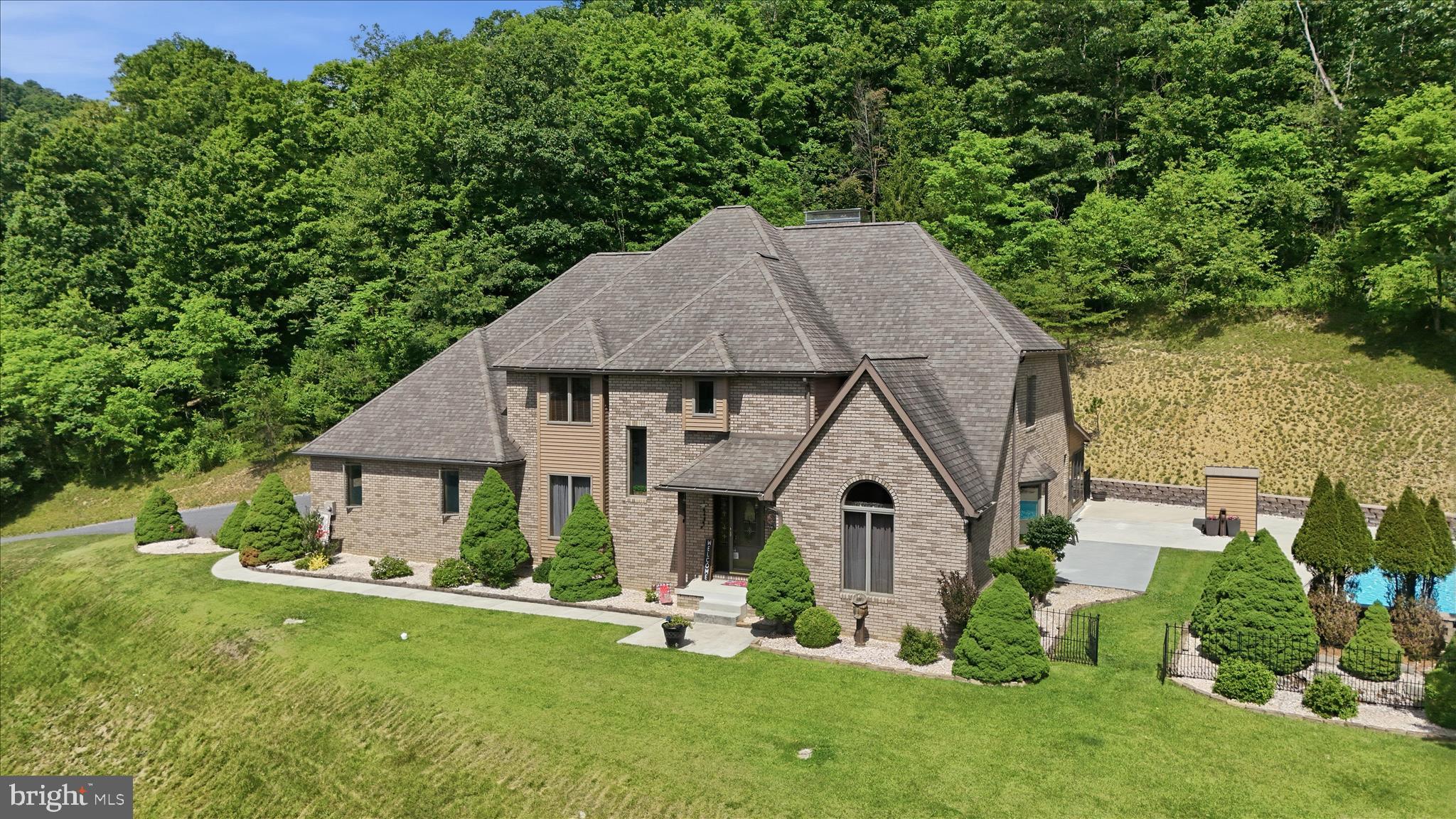 Welcome to your own private mountain-view retreat—where luxury, space, and convenience come together in one unforgettable package! Nestled on 6.75 acres in LaVale, this stunning 4,000+ sq ft contemporary has been impeccably maintained and delivers the perfect blend of elegance, comfort, and privacy—just minutes from shopping, dining, and I-68 access.
Step inside and prepare to be wowed by the dramatic great room featuring soaring cathedral ceilings, gleaming oak floors, and a striking double-sided gas fireplace—a true showstopper and the heart of the home. The layout flows beautifully into a chef’s dream kitchen with granite countertops, oak cabinetry, gas cooktop, double wall ovens, island + peninsula, and an inviting breakfast area.
The main-level primary suite is a peaceful escape, offering serene views of the backyard oasis and a spacious en-suite bath. The main level also includes a formal dining room, formal living room, den, sunroom, laundry room, and half bath—providing flexibility for both everyday living and entertaining.
Upstairs, you’ll find two generously sized bedrooms connected by a Jack & Jill bath, plus a large loft overlooking the great room—perfect for a home office, reading nook, or additional lounge space.
The lower level boasts a massive rec room, ideal for game nights, a home theater, or gym setup.
Outside is where this property truly shines—enjoy summer days by the in-ground fiberglass pool (15,000 gallons, new pump & motor 2025), take in the breathtaking mountain views, and appreciate the unmatched privacy of your expansive acreage. The property also features beautiful landscaping, a paved driveway, multiple sheds, and an oversized 2-car garage.
Built to impress with all-brick construction, Andersen windows, a 40-year roof, oak trim throughout, plus modern essentials like public water & sewer, central AC, gas heat, and a radon mitigation system already in place.
This is more than a home—it’s a lifestyle.
Impeccably maintained. Private. Scenic. Spacious. Convenient.
Opportunities like this in LaVale don’t come around often—schedule your tour today!