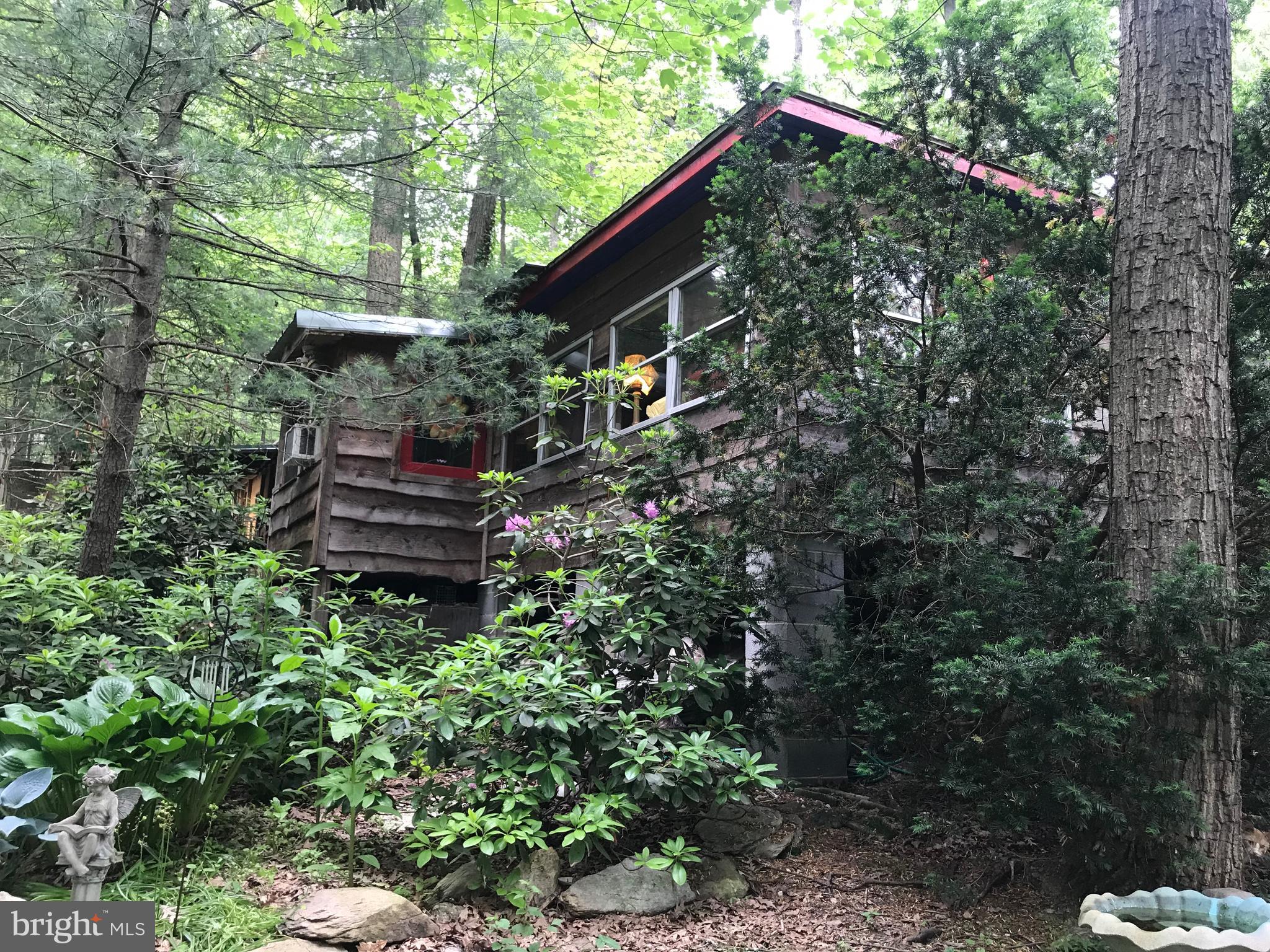 LOVELY GETAWAY HOME or full time living, this large private lot hosts wildlife, trees and a well landscaped 3000 gallon coy pond!  Enjoy the peace and quiet in your safe haven of a back yard! Cozy cabin includes kitchen, living room, laundry room and two potential bedrooms with bathroom in between.  If you are looking for land, in a location near the state forest, hunting, hiking and camp grounds, this is the home for you!