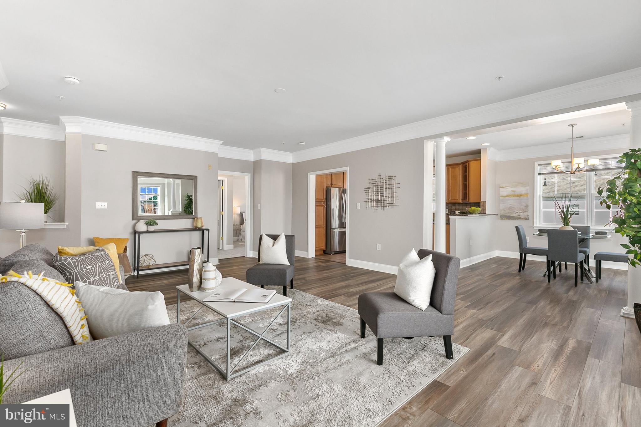 Stunning and light-filled 3rd floor corner unit in Rockville's highly sought-after King Farm Community. Boasting brand new luxury vinyl plank flooring in living areas and dining room and brand new carpet in the bedrooms you can move right in! This 2 bedroom 2 full bath meticulously maintained gem also features full size washer and dryer, 9 ft. ceilings, recessed lighting, and crown molding. Graciously enter into a spacious foyer with two closets and a niche shelf, perfect for displaying your favorite decorations. Spacious sun-drenched living room is ideal for everyday activities and entertaining. Lovely balcony accessed from dining room and den area is the perfect spot for morning coffee or all-day relaxing. Formal dining room grants amazing space to host dinner parties or simply enjoy a quiet casual meal basking in the natural light from the sliding glass door. Sparkling and functional kitchen has plenty of space to prep meals and cook with ease. Retreat to the primary suite with a walk in closet and private bath with two sinks, soaking tub and shower. Second bedroom also with a walk in closet tucked away on the opposite side of the condo features a private bath for added privacy for residents or guests.  Two assigned parking spaces.  One in secure garage with entrance into building lobby.  The other spot is in the rear parking lot with convenient access to the rear lobby. Tastefully decorated lobby is an impressive welcome for you and your guests.  Delight in all of King Farm's amenities including a clubhouse, two outdoor swimming pools, lighted tennis courts, basketball courts, softball fields, playgrounds, dog park, and a fitness studio. Across the street is King Farm Village Center where you will relish in shopping, casual eateries, fine dining, and Safeway. Free Shuttle to Shady Grove Metro! Truly a commuter's dream - only minutes to I-270, I-370, ICC, and Rte. 355.