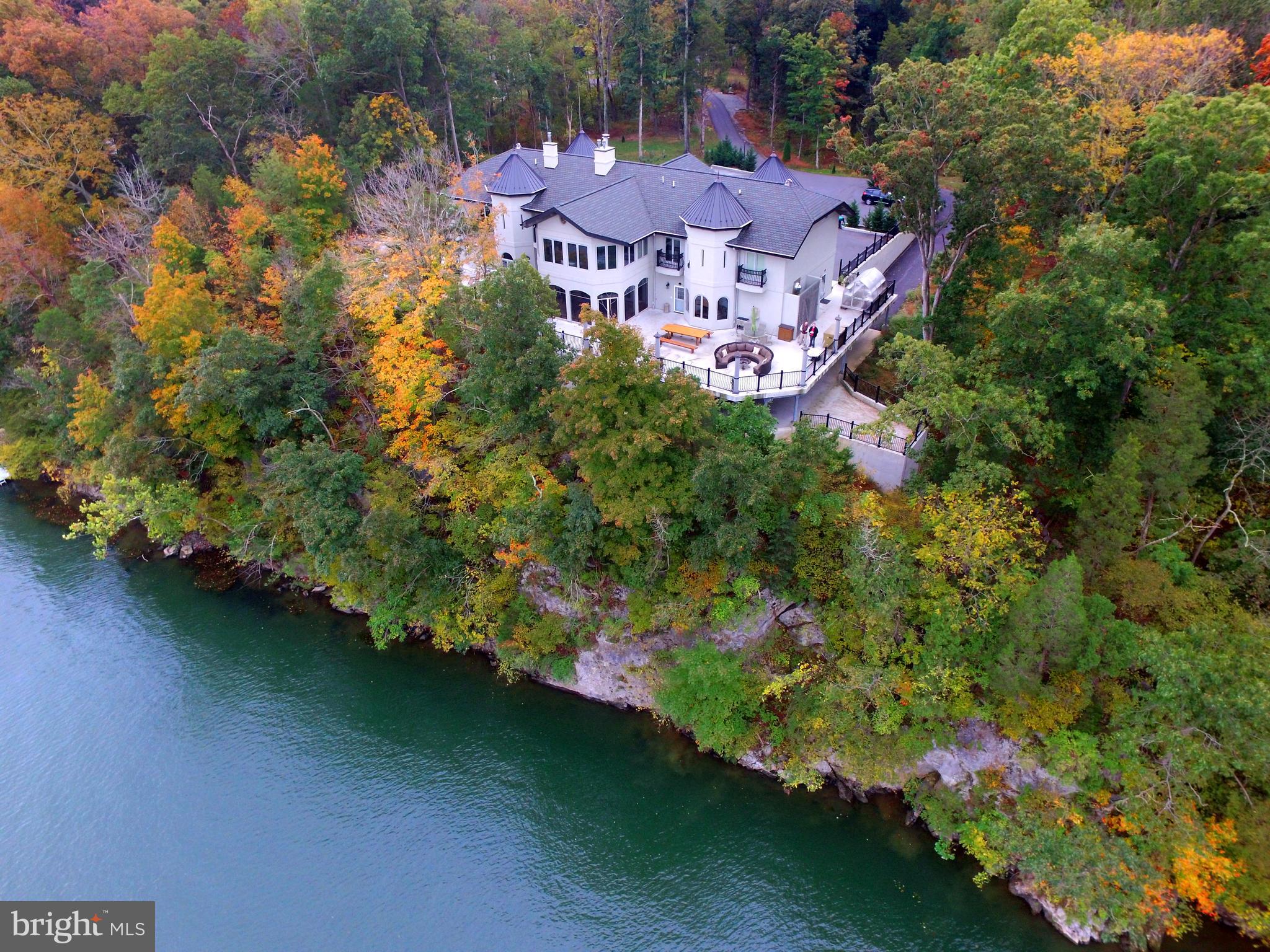 Graycliff  Hall is a magnificent, elegant CUSTOM RIVERFRONT13,545+ SQ. FT HOME, RETREAT CENTER  in the style of a 15th Century Tuscan Costello.  Sited on 13+ acres on the end of a long wooded driveway,  the estate features Magnificent 180 degree Potomac River Views!   It has 350 ft. of Potomac River front , the house is sited overlooking the river .
This  private retreat complex includes the large primary retreat  house,  a smaller guest cottage  and gate house with apartment for guests or managers. It is being sold FULLY FURNISHED!
MAIN HOUSE, features grand terrace overlooking the Potomac (views protected
by Federal Park, C & O Canal on opposite side of the river), The 1st floor is mostly open space  with large elegant areas and rooms. An elevator serves all three levels. Highlights include a wonderful huge fireplace area with large couches and a big formal dining area. Also a separate owners suite with kitchenette and office,a commercial grade gourmet kitchen, library and office. There is also a very large screened porch + huge decks with great  river views.  The second level has a large conference room and wet bar, 10 guest bedrooms all have balconies, 5 with river views. 6 full baths and 4 half bath.  The Lower level is largely finished as a recreational area with  a 24 seat theater room, 2nd office, open fitness area,  temperature controlled wine room,open game room with full sized bocce court,  pool table and video games, an open conference area with  conversation pit. Also a covered parking area on the lower level.  Multiple additional outbuildings, including a gatehouse with apartment and workshop,  a greenhouse, 2 bedroom  guest house along the edge of a large landscaped, stocked pond (decorative bridge provides access across a spillway for the pond- great aesthetic appeal) , a maintenance shop with storage loft, a warehouse and a gazebo overlooking the Potomac.  A canoe,  kayaks and a pontoon boat  convey along with golf carts, mowers and extensive equipment and tools  Sales includes one year membership to Cress Creek Country Club.    Graycliff is presently used as a family residence and corporate retreat center;  it serves as a perfect place to live and entertain family and friends;  a "retirement home to tempt the kids" with its outdoorsy, sporting lifestyle .  Your own private resort! It certainly will impress your business associates as they land on the Helipad that is included on the property.   It provides a place where friends, families and business associates could feel comfortable  in a  beautiful  natural environment, where kids could feel comfortable bringing their friends and their own families.  Perfect for a business residence. 
No matter the use, we guarantee that you will love the  natural beauty,  privacy  and the quiet atmosphere of this  grand property. As John Burrows once wrote, "I GO TO NATURE TO BE SOOTHED, AND HEALED, AND HAVE MY SENSES PUT IN ORDER."
Graycliff Hall is located within the Shepherds Cove residential community; a gated community with premium amenities, including miles of walking trails, and a community recreational area which fronts the Potomac River and includes a community boat storage area. 

The town of Shepherdstown is historic in nature, boasts small town charm,  contains a vibrant downtown area with  a wide variety of restaurants and  shops. Shepherdstown is the home of Shepherd University.
Shepherdstown is approximately 1 1/2 hours driving time from Baltimore and Washington DC.  
 For travel by air there is an Eastern West Virginia Regional Airport, easy access to Dulles International Airport ( IAD) , Baltimore Washington International Airport (BWI) National Airport ( DCA), and Washington County Airport (HRG).  
 The  station for Amtrak,  and MARC Commuter trains to Washington Union Station is within 20 minutes from the property.
Bring your family, bring your friends, bring your business. Can be used as a corporate retreat center.