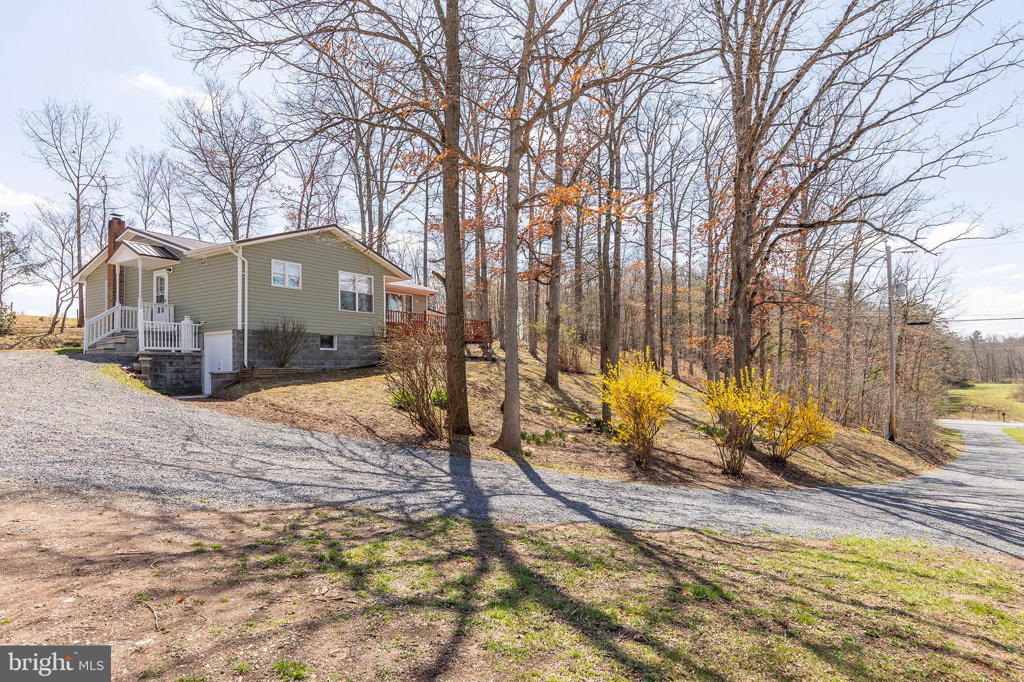 COUNTRY KING....ADORABLE RENOVATED RAISED RAMBLER ON 3.6 UNRESTRICTED ACRES OF BEAUTIFUL LAND IN SUPER CONVENIENT LOCATION. NEW EVERYTHING....ROOF, SIDING, PLUMBING, HVAC, FLOORING, PAINT, APPLIANCES.....NO FEARS OF UNEXPECTED REPAIRS UPON PURCHASE WHEN EVERYTHING IS NEW. WORK FROM HOME WITH FRONTIER FIBER INTERNET! DECK & COVERED CARPORT PROVIDE GREAT OUTDOOR LIVING SPACE TO ENJOY THE VIEWS OF ADJACENT FARMS. ABSOLUTELY GORGEOUS PIECE OF LAND....HOUSE IS TUCKED AWAY PRIVATELY ON A WOODED RIDGE WITH STREAM FLOWING ALONG THE EDGE OF THE PROPERTY, ABOUT 1/2 ACRE OF YARD/PASTURE FOR SMALL LIVESTOCK OR CHICKENS AND ENOUGH SPACE FOR A LITTLE HUNTING & SHOOTING. NICE WORKSHOP/SHED WITH LEAN-TO FOR EQUIPMENT. THIS HOME'S BEST ATTRIBUTE MAY BE IT'S LOCATION....JUST OFF THE PAVED ROAD AND WITHIN 1 MILE OF GAS STATION, POST OFFICE, RESTAURANT, DOLLAR GENERAL AND BRAND NEW ELEMENTARY SCHOOL....THAT'S WHAT YOU CALL COUNTRY CONVENIENCE! EASY 30-35 MINUTE DRIVE TO WINCHESTER, VA FOR COMMUTERS. IT SEEMS LIKE 300K DOESN'T GET YOU MUCH THESE DAYS BUT YOU'RE GETTING YOUR MONIES WORTH HERE! COMPLETELY RENOVATED HOME, 3.6 ACRES OF AWESOME UNRESTRICTED LAND AND A LOCATION THAT'S TOUGH TO BEAT....COUNTRY LIVING AT ITS FINEST!
