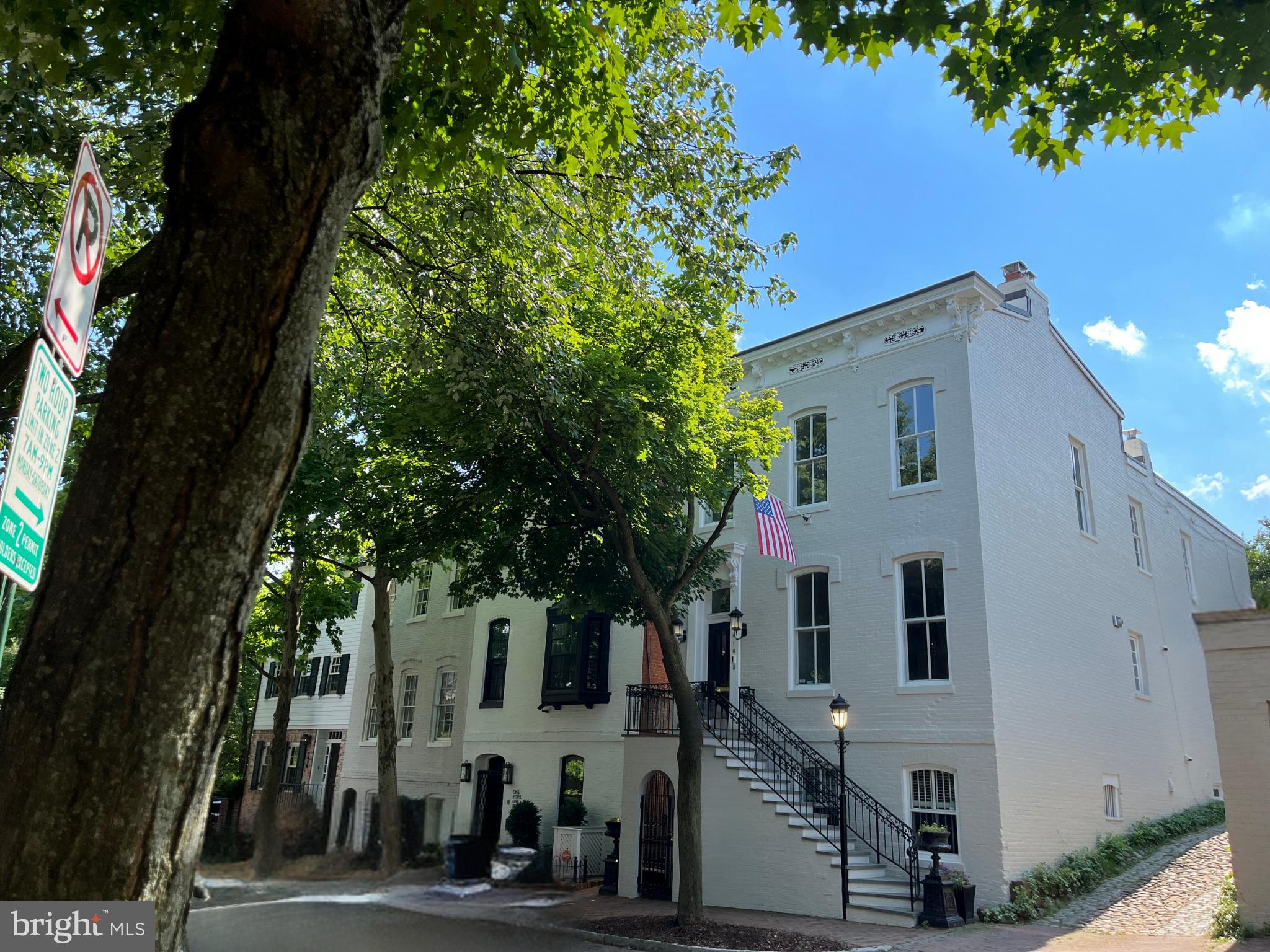 Quintessentially Georgetown, this detached home, built in 1876, has been substantially remodeled to seamlessly combine classic Federal architecture with modern amenities, providing the ultimate in livability and charm. Step through the vestibule to a light-filled main level featuring hardwood floors, high ceilings, crown moldings, a powder room, and gracious living spaces throughout. There is a modern eat-in kitchen with an adjoining breakfast area, a formal dining room with a fireplace, and a spacious living room facing out to the patio beyond a classic fireplace. Double French doors provide access to the lighted, hardscaped  private patio featuring a fountain, outdoor fireplace, garden and yard area, and a detached 2-level studio apartment with two levels that includes a studio area, living area, Full Bath, and 1-car parking.

Upstairs in the house, the Primary Suite features hardwood floors and an en-suite Full Bath, with separate shower and whirlpool tub, dual vanity, and water closet. Bedroom 2 features a stackable washer/dryer with access to a large attic space.  Spacious Bedroom 3 with a fireplace and built-ins, + Hall Full Bath with tub complete the Second Level.  The Lower Level is a full in-law suite including a large bedroom with a fireplace, a large versatile den, second kitchen, second laundry, full bath, and a separate front entrance. Elegant and distinguished, this detached property spanning nearly 3,900sf of interior living space is a rare offering in Georgetown's West Village.