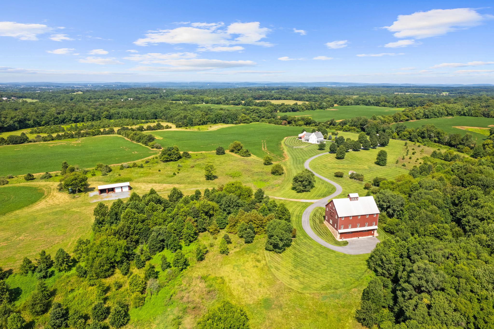 Stoney Springs Farm is unique, recreational, and extraordinary - 315+/- acres crafted for car collectors, hunters, equestrians, and agritourism visionaries alike.  Just 30 miles from Washington, DC, the property commands breathtaking panoramic views stretching from Sugarloaf Mountain to downtown Bethesda. For car enthusiasts or large-scale entertaining, the centerpiece is a masterfully BOWA built, timber-framed bank barn.  Spanning 8,200 square feet on three secure and climate-controlled levels, it features Douglas Fir beams and flooring, commercial-grade capability including a chain hoist and hydraulic lift, a full kitchen with high-end appliances, 1.5 baths, and the infrastructure to showcase and care for a collection of up to 20 exotic cars.  This estate also caters to the huntsman, offering mature woods, open fields, and strategically placed stands and food plots creating exceptional habitat and trophy opportunities.  The custom built, 4-bedroom, 3.5 bath colonial farmhouse is comprised of 4,800 finished square feet and features a coveted main level primary bedroom suite, a gourmet quintessential country kitchen with top-of-line appliances, gorgeous reclaimed oak floors, custom millwork, an oversized and versatile upper bonus room with rear staircase, inviting front and rear covered porches offering tranquil vista and spectacular sunsets, and is equipped with Geothermal HVAC.  Completing this unparalleled  property is a detached three-car garage with workroom and covered porch, and a substantial and functional four-bay agricultural building.  There are two high-producing wells, multiple productive crop fields and cultivable land, and is perc approved for an additional 6-bedroom house.  Nationally acclaimed magnet Poolesville High School and an array of restaurants are located less than three miles away. Thoughtfully designed and built from the finest materials, with two distinct visions, this incredible and vast property now invites a new owner to write the next chapter. This is more than real estate – it’s an opportunity to curate your own recreational oasis and enduring legacy!

*NOTE: There is no sign on property,  and please do not walk or drive on property without permission from listing agent.