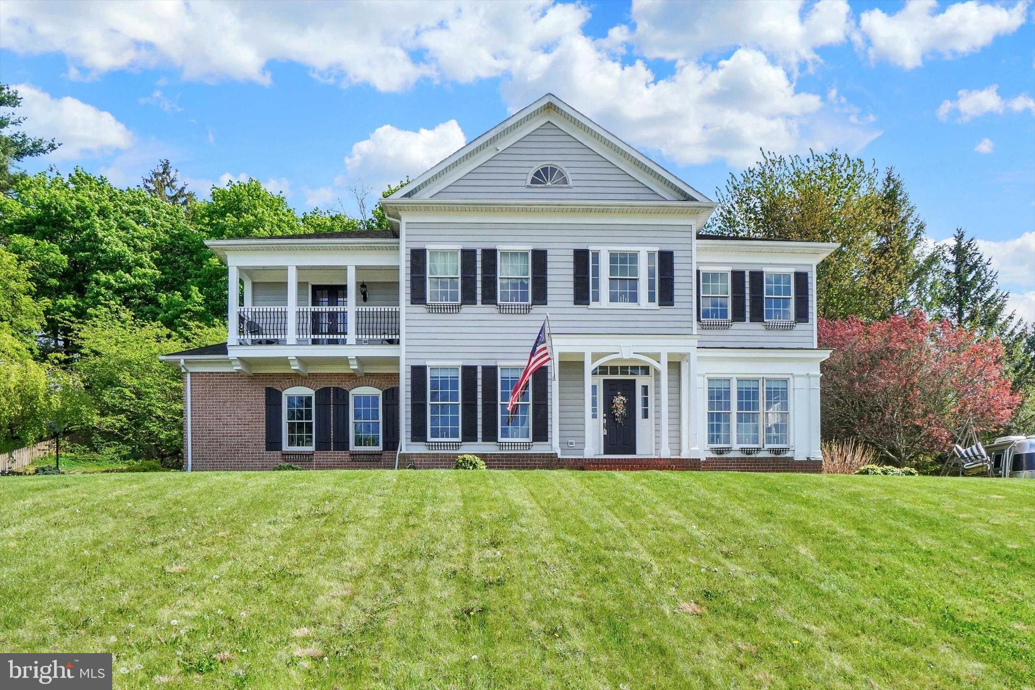 This home is located near a Park with tennis courts and pavilion and the Rail Trail for walking and biking, the 2 Story Foyer makes for an impressive entrance, hardwood floors, crown molding and picture framing add to the charm, the Kitchen has an island, a pantry, a Butler's Pantry, commercial size refrigerator/freezer, 6 burner & grill 9000 BTU dual zone stove and pot filler, the Primary Suite and bathroom offers 2 vanities, jacuzzi tub, separate shower, 2 Walk-in-Closets and door to balcony, there is a "Jack & Jill" bathroom between 2 additional bedrooms.  From the kitchen,  a door leads to a covered patio and wooded lot, the heating and air conditioning is 2 zoned, there are glass doors between Living Room and Family Room, the ceilings are 9 feet and 10 feet in the Basement, a Radon Mitigation System,  and there are pull down stairs in the Primary Bath Walk-in Closet