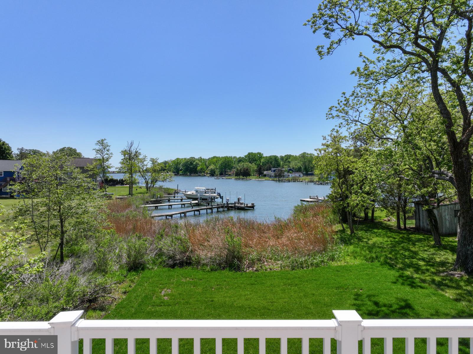 Discover the perfect blend of modern craftsmanship and coastal charm in this exceptional new construction home—already built and ready for you to move right in! The pier permit application was recently submitted! Access to the water from the yard is legally platted through the grasses as the water's edge. Peaceful water views all the way up the creek, open skies, and the simple pleasures of coastal living this home was designed and built by Whitehall Building & Company, known for meticulously crafted custom built residences with elevated finishes. This particular home  offers two levels of stunning waterfront living with walls of oversized windows on both levels showcase sweeping views of the creek and natural light that fills every room. Throughout the home, luxury wide-plank flooring and board-and-batten wall treatments add timeless warmth and architectural interest. On the main level, you’ll enter the home through a beautiful glass paned door and find a large family room with sliding glass doors opening to the back deck. This level also includes two bedrooms with large closet and each with its own en-suite bath, providing comfort and privacy for guests or family. The spacious open-concept reverse floorplan features soaring 16-foot vaulted ceilings on the upper level with wood beams and a cozy fireplace that sets the tone for relaxed yet refined living. The gourmet kitchen is a true showstopper, complete with a large island, stainless steel appliances, quartz countertops, and abundant cabinetry. There's a hidden, cabinet-faced door to a walk-in butler's pantry which provides exceptional functionality - generous storage space, built in shelving, a closet and countertop space. Imagine plenty of space for countertop appliance storage, beverage and food storage, as well as dishes or linen storage. The primary suite is also located on the upper floor to take advantage of the best water views and continue the home's sense of a coastal retreat. The luxurious primary bath was designed with dual vanities, a soaking tub, and a separate shower. An additional bedroom and en-suite bath are located on the upper level. Outdoor living is equally memorable, with two expansive decks which are a wonderful extension of your entertainment space on both levels. Whether privately enjoying your morning coffee or hosting friends for sunset gatherings, these outdoor spaces invite you to truly embrace the laid-back waterfront lifestyle. There is a two car garage.   2-3 ft water depth anticipated at the end of the pier. Come and make this stunning waterfront retreat your new home. Enjoy the scenic shores of Parker Creek in the vibrant waterfront town of Deale, a community rich with character, multiple marinas, and a variety of great dining options. All within a convenient distance to DC or Annapolis. The pier permit drawing attached in disclosures and in photos