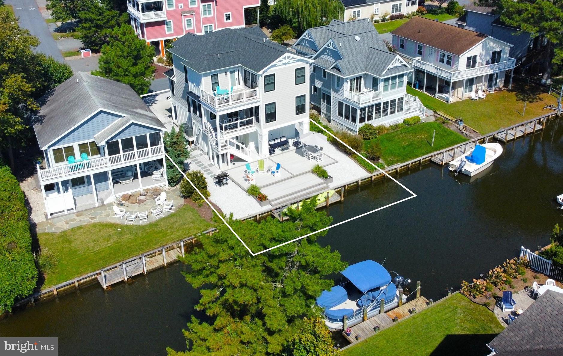 This exquisite canal-front home was thoughtfully designed with exceptional attention to detail and showcases luxury finishes throughout. The impressive great room seamlessly blends a gourmet kitchen, dining area, and living space, all opening to a waterfront balcony with stairs leading to an expansive deck and boat dock—perfect for easy waterfront living and entertaining. The main level also features a convenient half bath and a stunning primary suite complete with a spa-like bathroom offering dual vanities, a walk-in shower, stacked washer/dryer, and a spacious walk-in closet. Upstairs, you’ll find an additional family room with a wet bar, mini fridge, and microwave, along with access to a sun deck. This level also includes a second en-suite bedroom, two additional generously sized bedrooms, a full hall bath, and a dedicated laundry room. The ground level welcomes you with a foyer, half bath, and access to an oversized garage with ample storage, an EV charging outlet, and elevator access servicing all floors. Step outside to enjoy the covered patio, expansive waterfront decking, and large outdoor shower—ideal after a day at the beach or on the water. Built for low-maintenance coastal living, the home features durable HardiePlank siding, and composite decking. Gas propane line hookups on the deck make outdoor grilling and fire pit gatherings effortless. Located just two blocks from the beach, enjoy a short, easy walk to the wide, lifeguarded beaches of South Bethany. For water enthusiasts, dock your boat just steps from your back door and spend the day boating, jet skiing, or kayaking. Rarely does a home of this quality, design, and location come to market—this is coastal living at its finest.