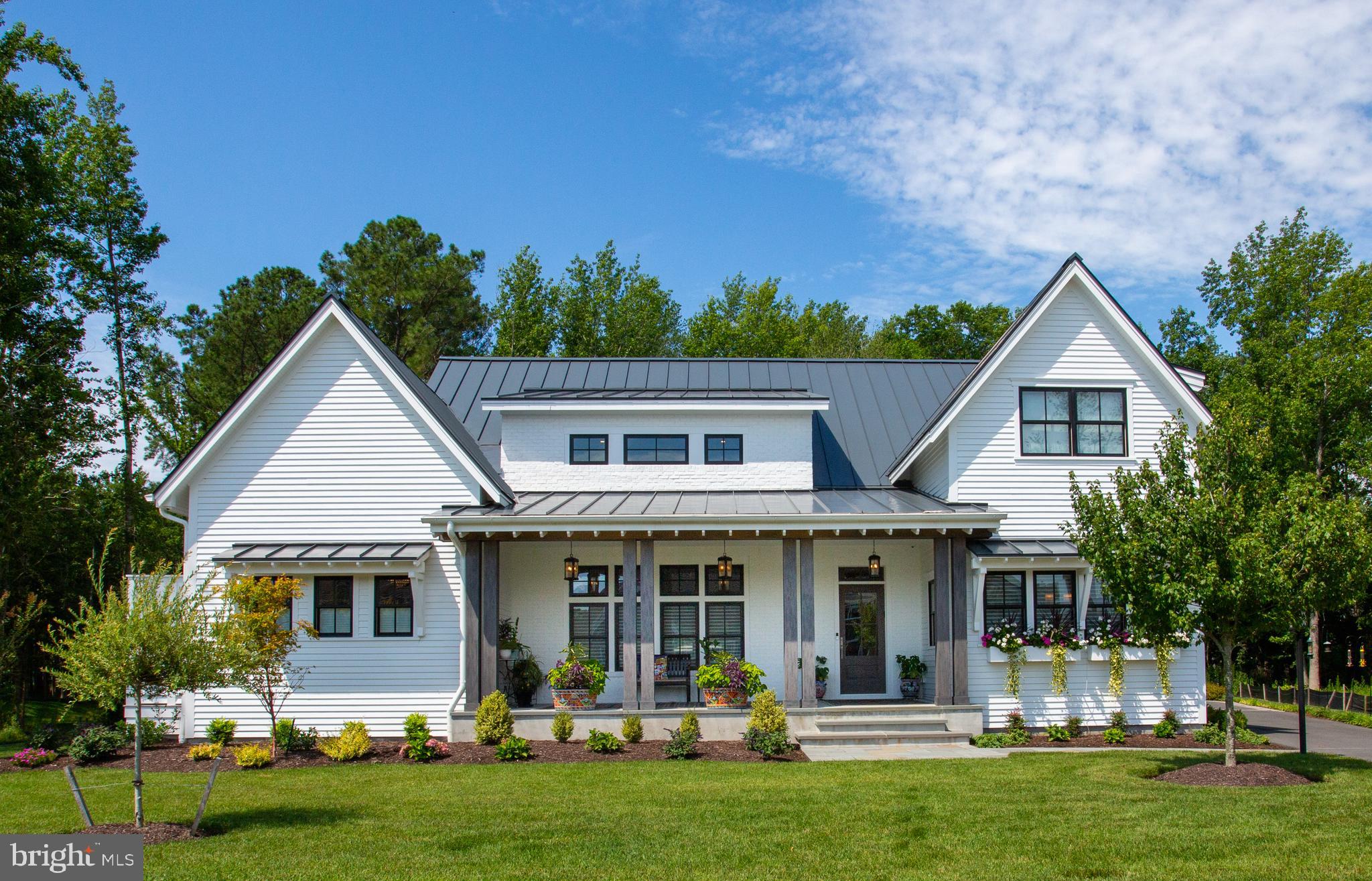 Welcome to 417 Virden Way, an exceptional custom-built home in the sought-after Lewes community, Mariners’ Retreat. Situated on the most desirable lot in the neighborhood, this post-modern farmhouse sits on .32+/- acres, backs to wooded open space, and is less than a ½ mile from the shops and restaurants along 2nd Street, the Lewes Rehoboth Canal and within 1 mile of Lewes Beach. Manicured landscaping and a spacious stone front porch set a warm and welcoming tone. Upon entry, you’ll quickly recognize the crisp clean lines, meticulous maintenance, and timeless appointments including wide plank white oak flooring, shiplap and vaulted ceilings, expertly crafted built-ins, and more. Boasting 4 bedrooms, 5.5 baths, and 3,850 square feet this open-concept floorplan offers an abundance of light and is ideal for entertaining. The spacious eat-in gourmet kitchen is designed with striking, yet classic, marble counters and backsplash which extends to the ceiling, an oversized island with breakfast bar, elegant lighting fixtures, and commercial-grade stainless steel appliances. The first floor was designed with two living areas featuring a wall of built-ins, gas fireplace with a breathtaking marble surround, wet bar with beverage fridge, and media lounge. A unique pocket slider lets you bring the outside in and connects to the screened porch, while also offering a view of the sleek, heated, gunite pool with comforting water features and an inset spa. Off the living room is an ultra-private primary suite accessible through hidden doors designed to blend into the great room’s custom cabinetry. The primary suite offers a cozy sitting room, bedroom with vaulted ceilings, dual walk-in closets, and a luxurious en-suite bath with gorgeous marble tile, dual vanities, mulit-head, spa-style shower with interior access to a private outdoor shower. The second level of this stunning home is host to a recreational room, and 3 generously sized bedrooms each with upscale, en-suite baths. Additional features include a smart home system allowing you to control lighting and audio/video throughout the home at the push of a button, private backyard with beautiful hardscape, landscaping, outdoor bath and grilling station, an oversized conditioned 3-car garage, unfinished insulated walk in-attic, ample closet space, expansive laundry room, and so much more. Truly an exceptional property in downtown Lewes.