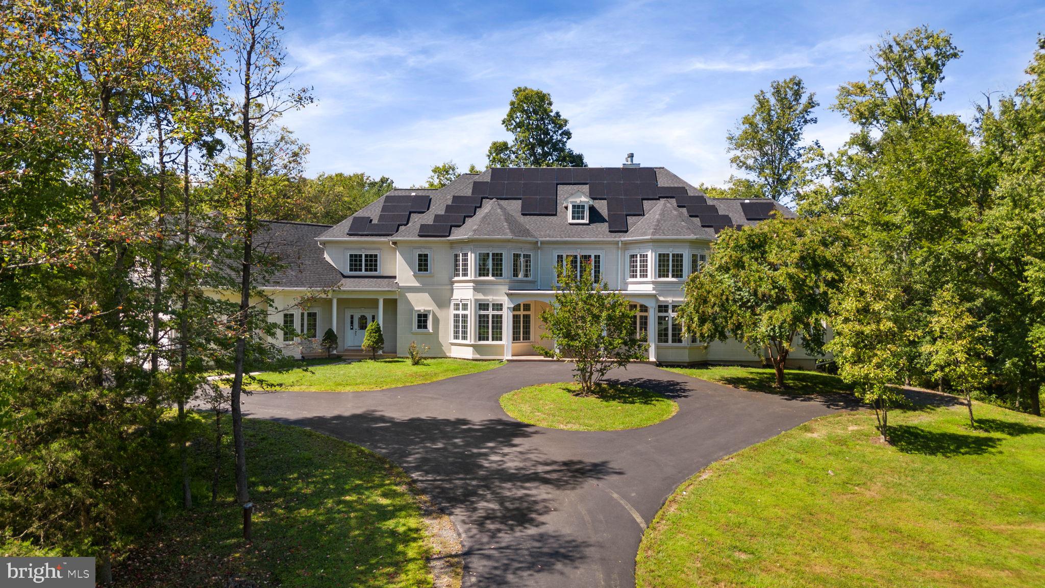 A stunning expansive show stopping custom estate  in Fairfax Station with over 9,000 finished square feet is waiting for you!  Through the custom glass and iron double front doors you are greeted with a massive entry foyer, a large spiral staircase, newly installed warm cherry hardwood floors, formal dining room, soaring two story living room with marble floors, wood burning double sided fireplace, floor to ceiling windows bringing in loads of natural light.  The main living area is rounded out with a wet bar and butler’s pantry that accompanies the elegant two story living room.  On the right wing of the house is a main level bedroom with a full bath that was just renovated with stone tile.  There is  an expansive office with a two sided wood burning fireplace with marble hearth.  The large gourmet kitchen has a second wood burning fireplace,  a laundry room/mud room as well as a powder room for guests and two exits to front and rear covered porches. The gourmet kitchen has a large island for entertaining with a brand new Kitchen Aid cook top, exhaust fan and pendant lights.  In the kitchen, there is space for a large table and all appliances are new and state of the art stainless steel.  The kitchen has tons of storage, gorgeous new granite counters, luxurious marble tile floor, double wall oven, built in microwave and a large walk-in pantry. This elegant home has recently been painted a neutral palate, boasts new carpets, updated bathrooms and light fixtures. The entire main level has crown molding throughout.  This expansive home has 7 bedrooms with a main level bedroom and full bath, a lower level bedroom and full hall bath, a primary bedroom suite on upper level with 4 other secondary bedrooms that all have their own bathrooms and walk in closets on the upper level! There is a second stairway off the kitchen that leads to a wing of bedrooms. The lower level has a bedroom and full bath as well as a large recreation room, and two other flex space rooms.  The basement is a walk out to the rear yard.  So much is new! The lower-level bathroom and main level bathroom were recently renovated with gorgeous stone tile.  The house has a brand-new roof and gutters and two brand-new hot water heaters just installed in Sept 2023.  The septic system was upgraded and replaced in 2023.  The house is also adorned with solar panels that cover the electric bill currently, with a savings of over $1,000 per month! The solar panels provide green credits and allow for $0 power bill!  The house is also a smart home that monitors water consumption to report any leaks, monitors electricity and heating and air conditioning. There is an additional detached building which is studio/office space that is being sold as is.  The structure has its own electricity, heating and air conditioning.  It is not hooked up to water or septic at this time.  The new owner can apply for an accessory dwelling unit permit and have water and septic attached with a permit from Fairfax County.  Outdoors to your right is a wooden bridge that takes you over to a huge side yard for games and entertainment. The house has a convenient and spectacular circular driveway with ample parking, new asphalt driveway and a side load three car garage.  This home is close to commuter routes and in a sought-after school district and neighborhood.  The home is about a mile from the VRE station and close to so many wonderful restaurants and shopping. The current owner has spent $400k+ on updates, renovations and upgrades to this magnificent home! Nothing left to do but move in!