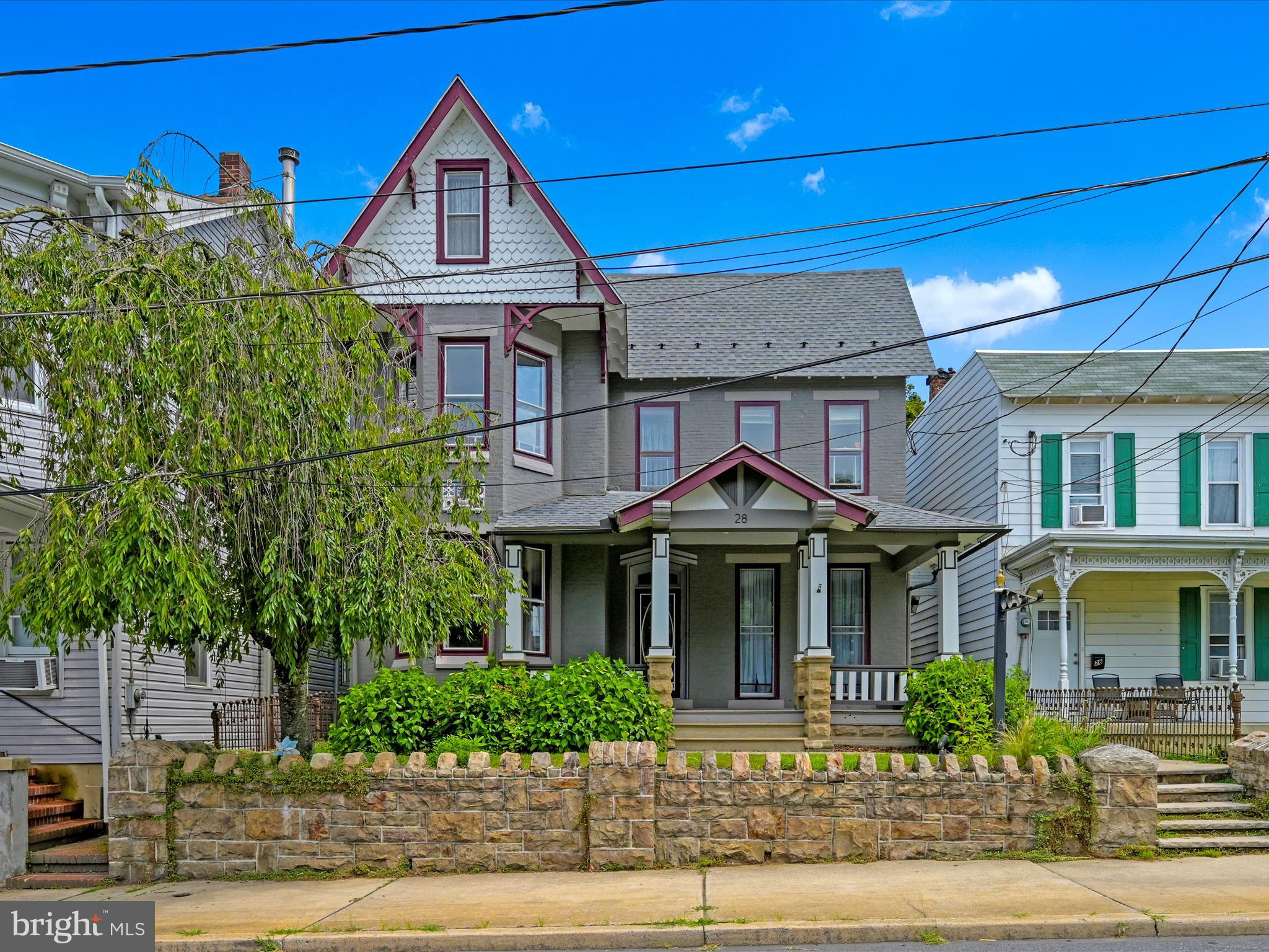 What are you waiting for?  This home offers so much character and space!  Welcome to this beautifully maintained Victorian home located in the desirable Schuylkill Haven area. Zoned R-2, this property offers a unique opportunity to enjoy both residential living and professional office space. Used as a single-family home and an accounting office for over 30 years, it is ideally situated just outside the business district, within walking distance to the library, post office, pharmacy, grocery store, banks, and more. The inviting front porch, framed by blooming hydrangeas and wisteria, provides a front-row seat to community parades, fireworks, and annual Borough Day celebrations. Inside, the main foyer showcases original hardwood floors, high stunning ceilings, and preserved woodwork with a combed finish. The spacious living room features bay windows with original wooden shutters and a decorative fireplace, flowing seamlessly into the formal dining room through stunning 18-paned glass French swinging doors. The kitchen was fully renovated in 2020 with solid wood cabinetry, black stainless steel appliances, subway tile backsplash, open shelving, and black-and-white luxury vinyl plank flooring. A charming pass-through connects the kitchen to the dining room. The adjacent laundry room includes a vintage laundry tub, built-in folding table, tons of storage and would make a great mud room with outdoor access. Step out to the private backyard, complete with a patio, garden beds, white picket fencing, and off-street parking for four vehicles. A restored wrought iron gate provides side entry to this inviting outdoor space. The main level also features a dedicated office area with a separate exterior entrance, new carpet and fixtures (2019), and two large walk-out windows. This space includes an 8’ pocket door and offers flexible use as a home office, first-floor bedroom, gym, or additional family living area. A full bathroom with matching luxury vinyl flooring is located just behind the office. Upstairs, you’ll find four spacious bedrooms with wide-plank hardwood floors and beautiful details, including colored glass accents and bay windows. The full bathroom features a vintage-style pull-chain toilet and a clawfoot tub. A walk-in closet and original bonus closet offer generous storage. The third floor includes a finished bonus room with heat and carpeting, perfect for a fifth bedroom, den, or playroom. This home offers the perfect blend of historic character, thoughtful updates, and versatile functionality—all within a vibrant small-town setting. Don’t miss your chance to own this one-of-a-kind property. Schedule your showing today!  **SELLERS WILL CONSIDER ALL LOAN PROGRAMS/TYPES**