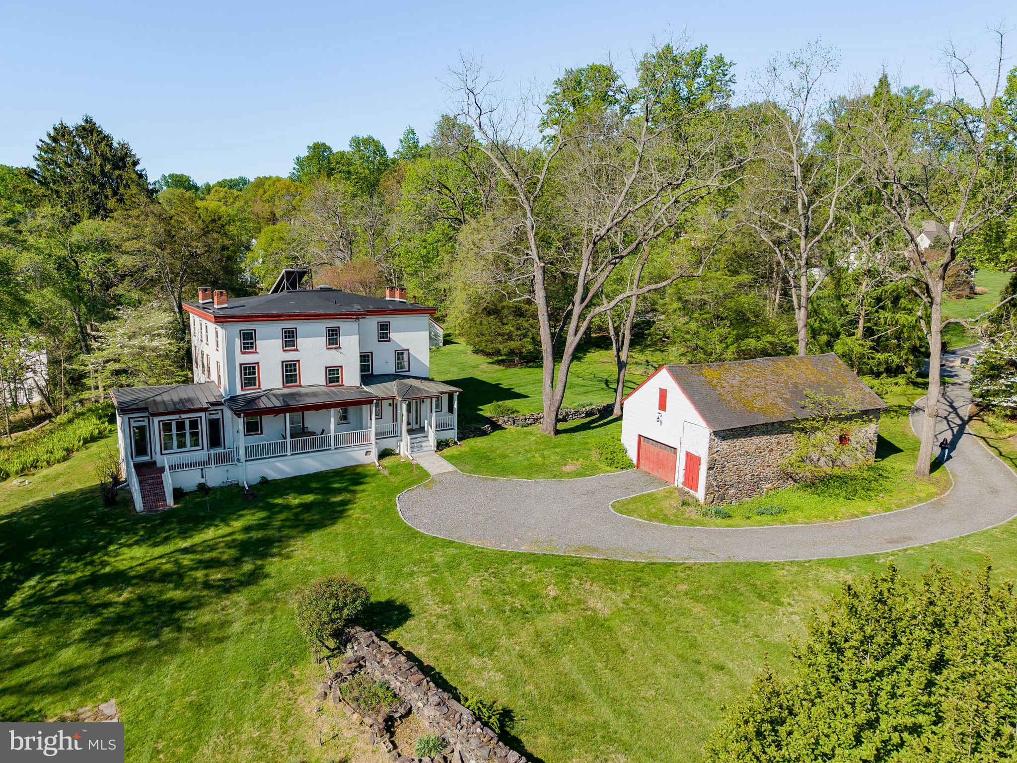 Welcome to 95 Indian Spring Road, a truly special 3 story, 6 bedroom, 3 full bath, 1 half bath historic property offering over 5,000 square feet of living space on 2.3 scenic acres in Media. Tucked at the end of a cul de sac in a beautiful neighborhood surrounded by other luxury homes, this property feels private and estate-like while still being close to everyday conveniences. Rich with character and thoughtfully updated over time, this home offers the rare combination of historic architecture, flexible living space, and unique outbuildings that create endless possibilities.
From the moment you arrive, the home’s welcoming front porch sets the tone, offering a charming place to take in the property’s peaceful setting. Inside, beautiful natural light fills the interior, built in shelving lines the living area, and original hardwood floors are found throughout most of the home, adding warmth, character, and timeless appeal. The main level offers generous living and dining spaces, multiple gathering areas, 3 working fireplaces, a thoughtfully updated kitchen addition, and convenient everyday functionality, including a first floor bathroom added as part of the kitchen expansion. The second floor features 3 bedrooms, 2 full baths, and a laundry room. The third floor offers 3 additional bedrooms, 1 full bath, and another bonus room with more storage. A full basement, partially finished with access to the outside, adds even more usable space for recreation, storage, or hobbies.
Outdoor living is another highlight of the property. In addition to the classic front porch, the rear brick patio and porch were completely redone in 2022 and feature beautiful white pillars that create a graceful transition from the home to the surrounding acreage. The 2.3 acre setting continues to impress with a two story garage barn offering excellent space for parking, storage, or workshop use.  An  historic Smokehouse sits on the property complete with a fireplace that creates a one of a kind opportunity for an art studio, fitness space, garden retreat, private office, or quiet escape. Whether enjoying morning coffee, entertaining, or quiet evenings overlooking the grounds, the outdoor spaces add to the private, estate-like feel of the property while still being close to the conveniences of Media.
The sellers have made meaningful updates during their ownership, including connection to township sewer in 2006, connection to AQUA public water in 2021, complete updated electrical services, installation of a high efficiency gas furnace in 2021, a newer water heater installed in 2022, and replacement windows on the first and second floors in 2023 and 2024, with the exception of the laundry room. Additional improvements include the front porch completed in 2002, the kitchen addition with partially finished basement, and ongoing care to the home’s systems and features.
This home holds rich historical significance. Known in historic records as the “White House,” the main residence was built in 1858 and showcases classic Georgian influence, stone and stucco construction, and the enduring presence of an early Pennsylvania estate. Historic records connect the property to the Bishop family and trace the land’s ownership history back to a William Penn grant in 1684, adding a remarkable sense of heritage to the home. This is  a rare opportunity to own a property with both architectural and local historical significance.
Ideally located just minutes from Media Borough, local parks, shopping, dining, and major routes, 95 Indian Spring Road is for the buyer who values history, space, character, and possibility. Schedule your private showing and experience all this remarkable property has to offer!