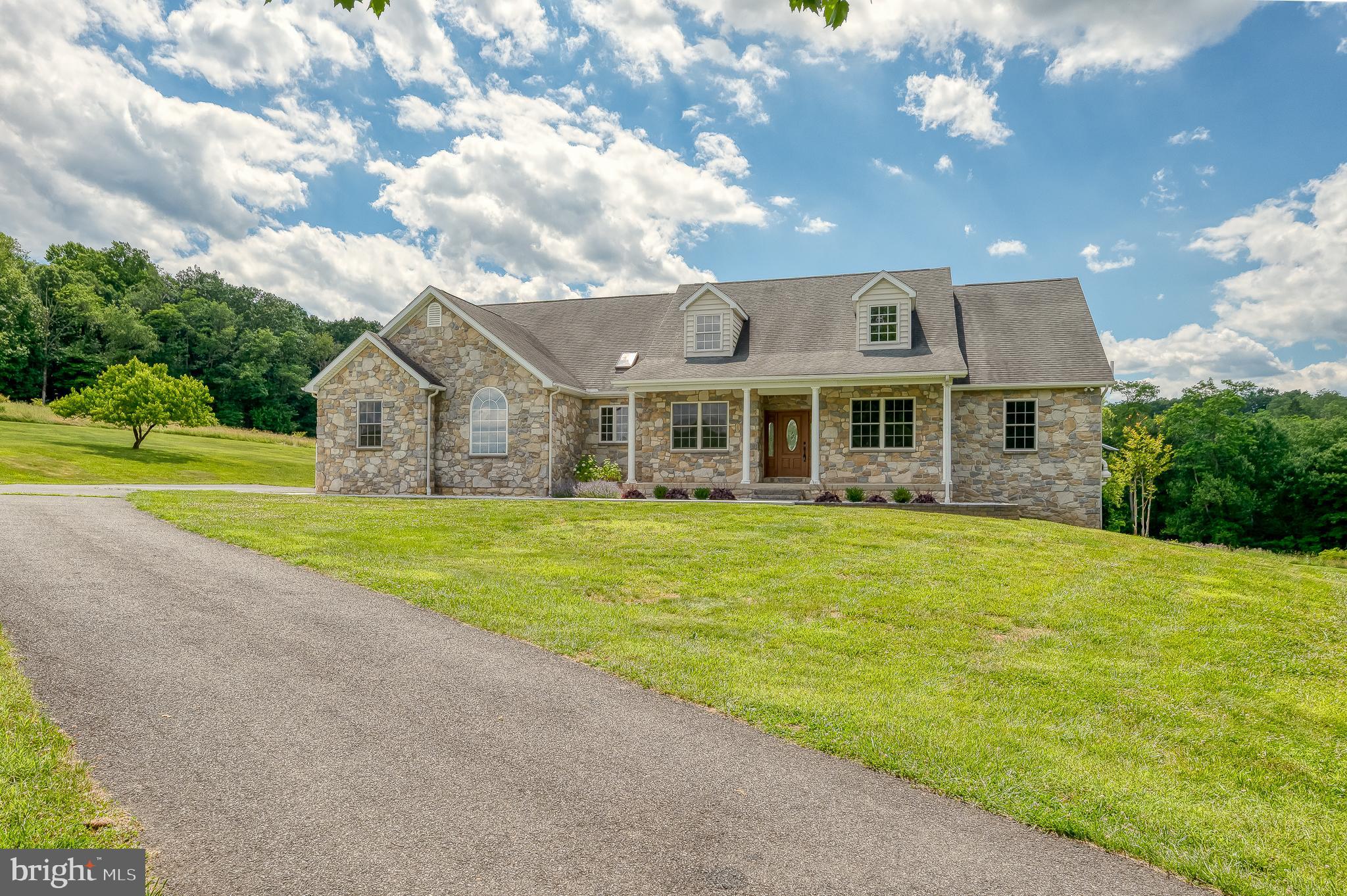 Must See!  This stunning custom-built stone rancher with a three-car garage showcases exceptional craftsmanship, luxury finishes, and meticulous attention to detail throughout. Completely refreshed with extensive high-end upgrades, this home offers the perfect blend of timeless design and modern convenience. The fully renovated chef’s kitchen (2025) features premium GE Monogram appliances, elegant quartzite countertops, and an impressive 10-foot prep island, creating a beautiful and highly functional space for cooking and entertaining. Throughout the home you’ll find all-new ¾-inch solid oak hardwood flooring (2025) along with updated lighting and fresh paint (2025) that add warmth and sophistication to every room. Major mechanical updates include a new HVAC system (2024) featuring an energy-efficient Bosch heat pump with backup propane furnace, providing year-round comfort and efficiency. The hall bathroom and laundry room were tastefully updated in 2024, complemented by new washer and dryer for added convenience. Step outside to enjoy thoughtfully designed exterior improvements including a new concrete sidewalk, retaining wall, and low-maintenance landscaping, all leading to a beautiful patio retreat surrounded by peaceful wooded views and expansive open space—an ideal setting for relaxing or entertaining outdoors. With countless upgrades, luxurious finishes, and a tranquil setting, this exceptional home truly offers move-in ready living at its finest.