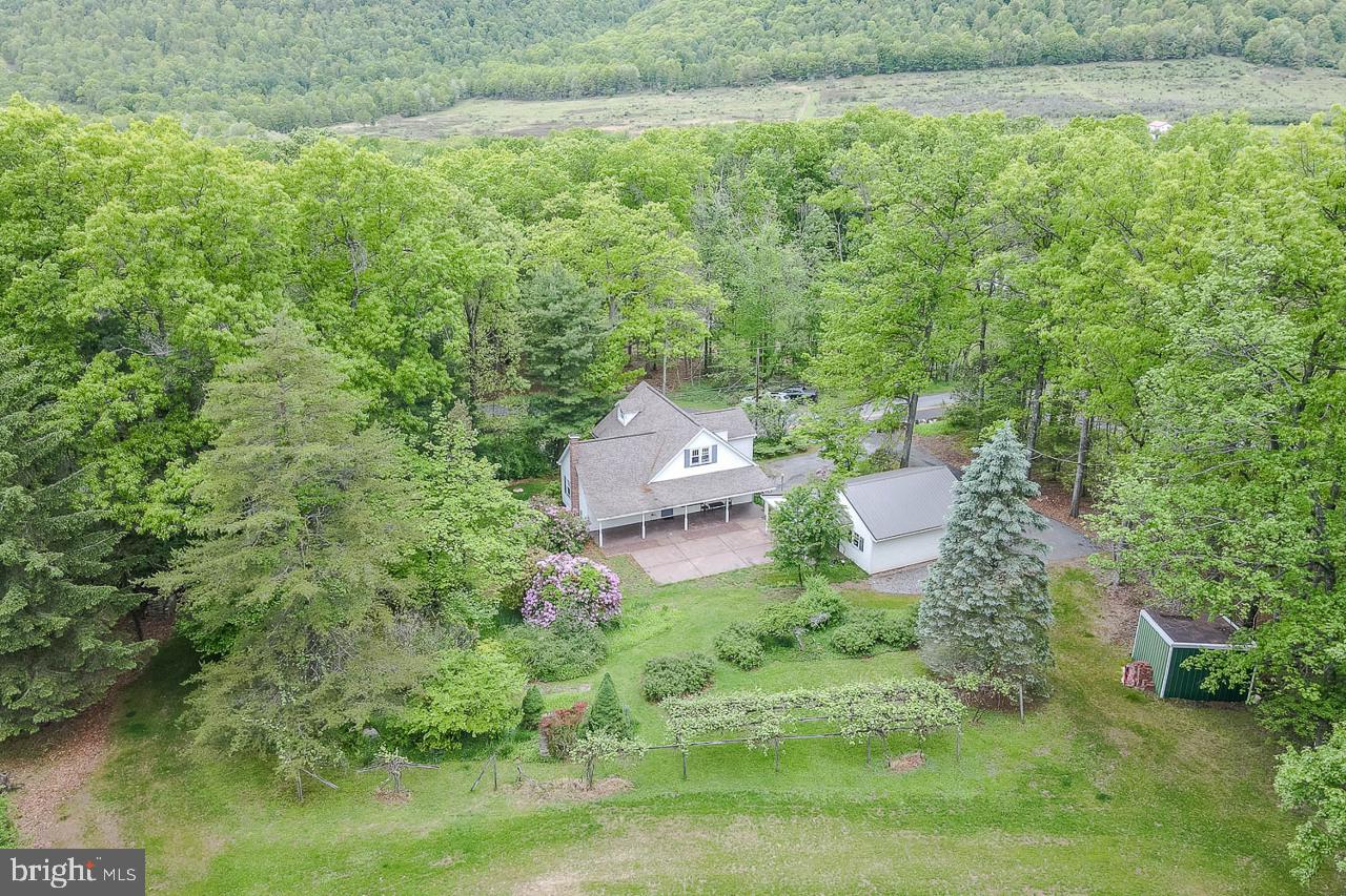 Tucked into the peaceful hollows of Tyrone, this beautifully updated Cape Cod combines charm, functionality, and thoughtful improvements throughout. Inside, you’ll find custom oak hardwood plank flooring, solid oak interior doors, and a warm, inviting layout designed for comfortable everyday living. The remodeled kitchen features granite countertops, stainless steel appliances, abundant cabinetry, and a large center island with excellent storage and workspace.

The spacious first-floor primary suite offers a walk-in closet and private full bath, while the main level also includes a generously sized guest bath with laundry area. Upstairs provides flexible living space with two to three additional bedrooms, or the option for a home office, den, or hobby room. The finished lower-level family room features a cozy gas fireplace, creating the perfect setting for relaxing or entertaining.

Recent major improvements add peace of mind, including a newly installed septic system and basement waterproofing enhancements. A newer detached two-car garage complements the integral garage, providing ample parking, storage, and protection from the elements. The property also includes two functional wells. A newer well servicing the home and a secondary well ideal for outdoor use and landscaping.

Situated on approximately 1.5 acres, the outdoor space is equally impressive with mature landscaping, blooming rhododendron and laurel, grapevines, apple and plum trees, a large concrete patio, and two covered porches perfect for enjoying the quiet surroundings. Whether you're looking for space to entertain, garden, or simply unwind, this property offers a little bit of everything.